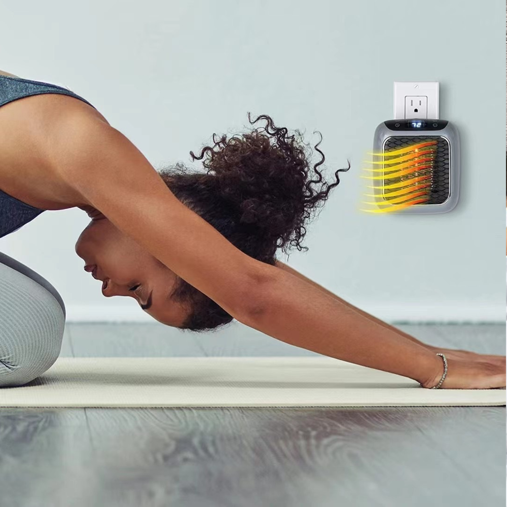 Frau in Yoga-Pose auf Matte. Ein Wandheizer ist eingesteckt. Der Raum hat Holzboden.