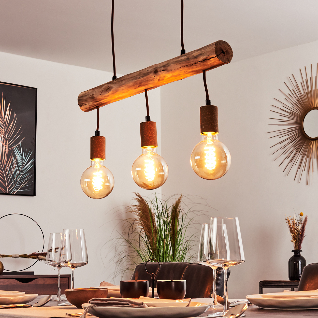 Holzbalken mit drei hängenden Glühbirnen. Tisch mit Gläsern, Tellern und Dekoration. Warmes, einladendes Interieur.