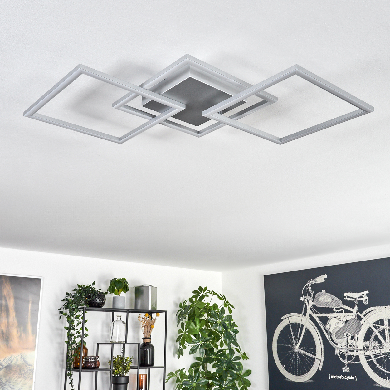 Deckenleuchte mit quadratischem Design. Darunter ein Regal mit Pflanzen und eine Motorradzeichnung.