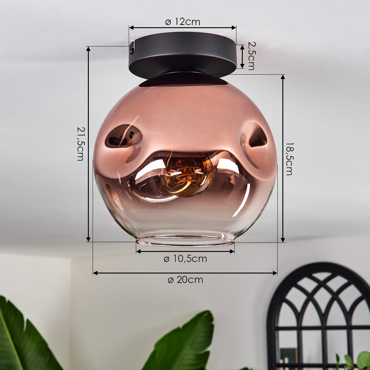 Eine moderne Deckenlampe mit kupferfarbenem Glasschirm. Maße werden angezeigt. Eine Pflanze und ein dekoratives Fenster sind im Hintergrund.