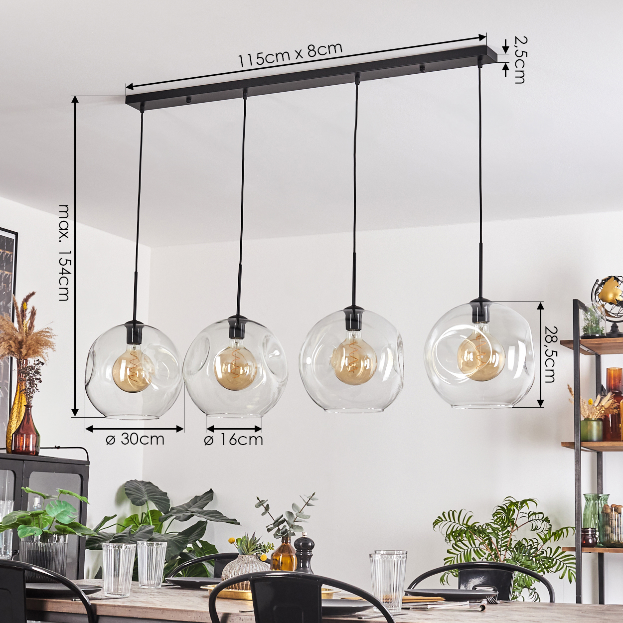Vier Glaskerzen mit sichtbaren Glühbirnen hängen über einem Tisch. Abmessungen sind angegeben. Pflanzen und ein Regal sind im Hintergrund.
