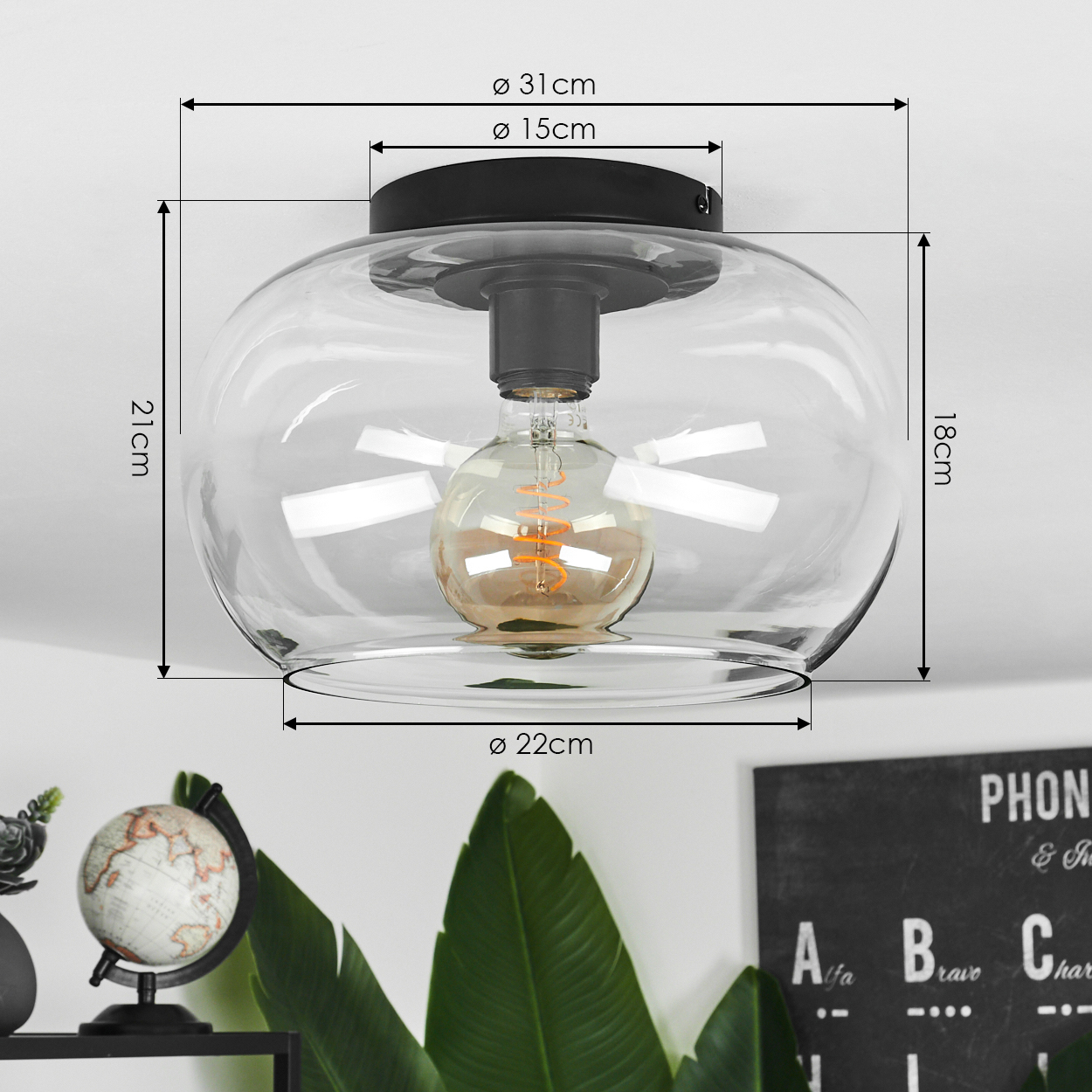 Eine transparente Glas-Deckenlampe mit sichtbarer Glühbirne, Abmessungen und Dekorationen wie Globus und Tafel im Hintergrund.