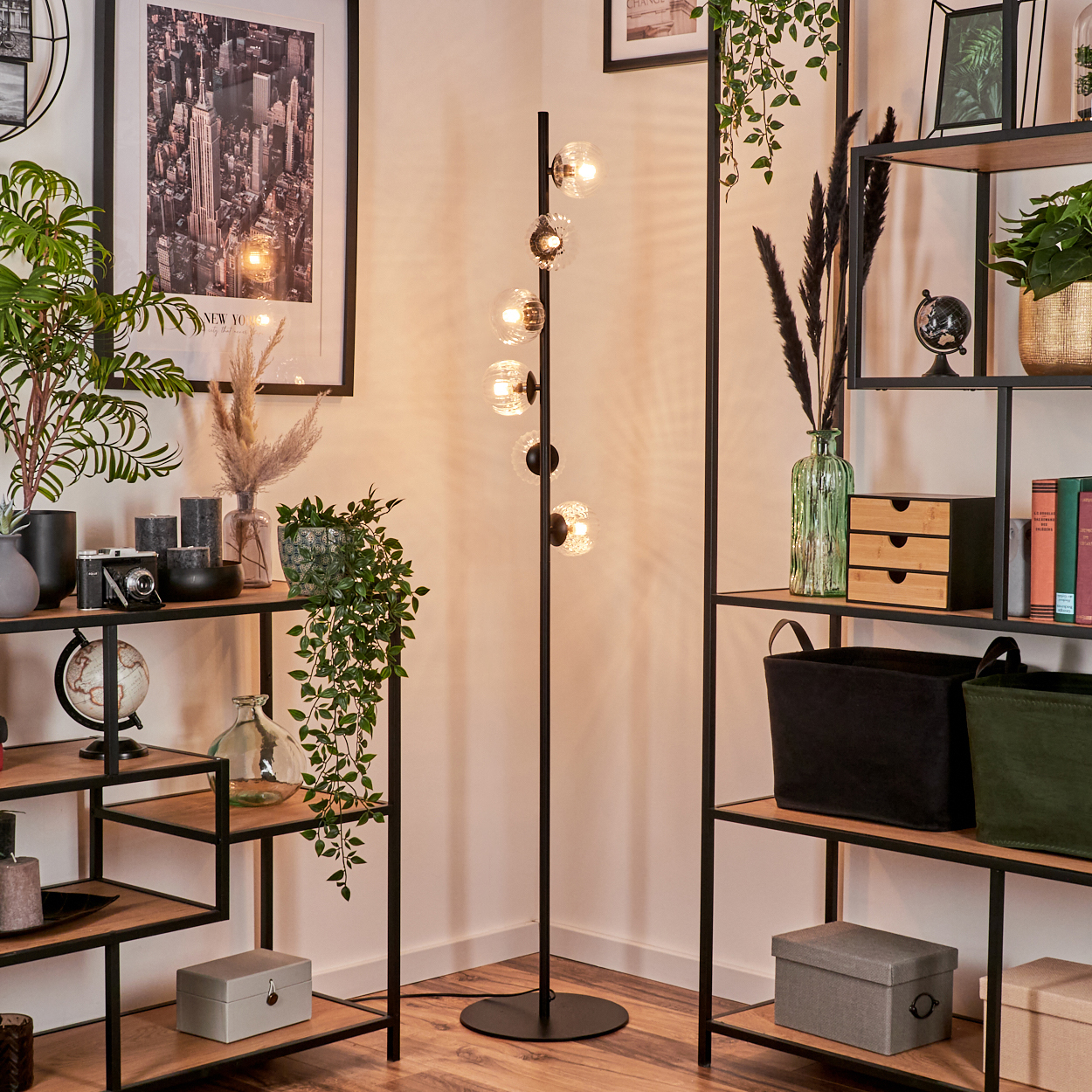 Raumecke mit Regalen, Lampe und Deko. Regale halten Pflanzen, Bücher und Boxen. Ein New York City Poster hängt an der Wand.