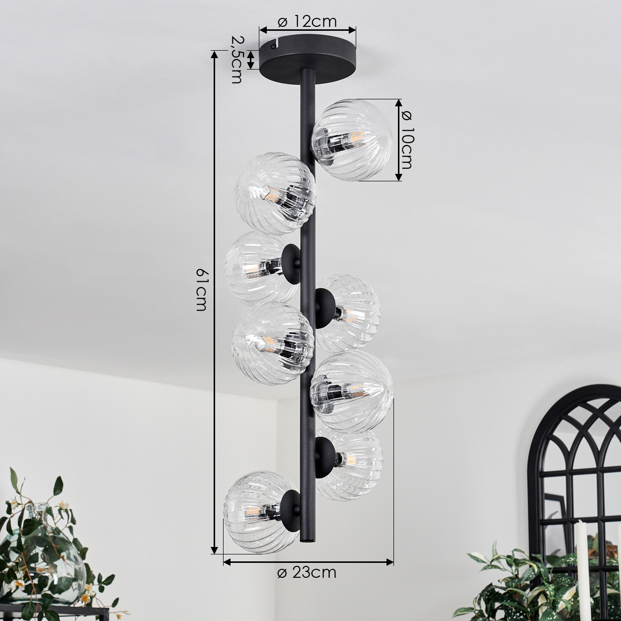 Eine moderne schwarze Pendelleuchte mit klaren, gerippten Glaskugeln hängt von der Decke. Abmessungen sind auf dem Bild angegeben.