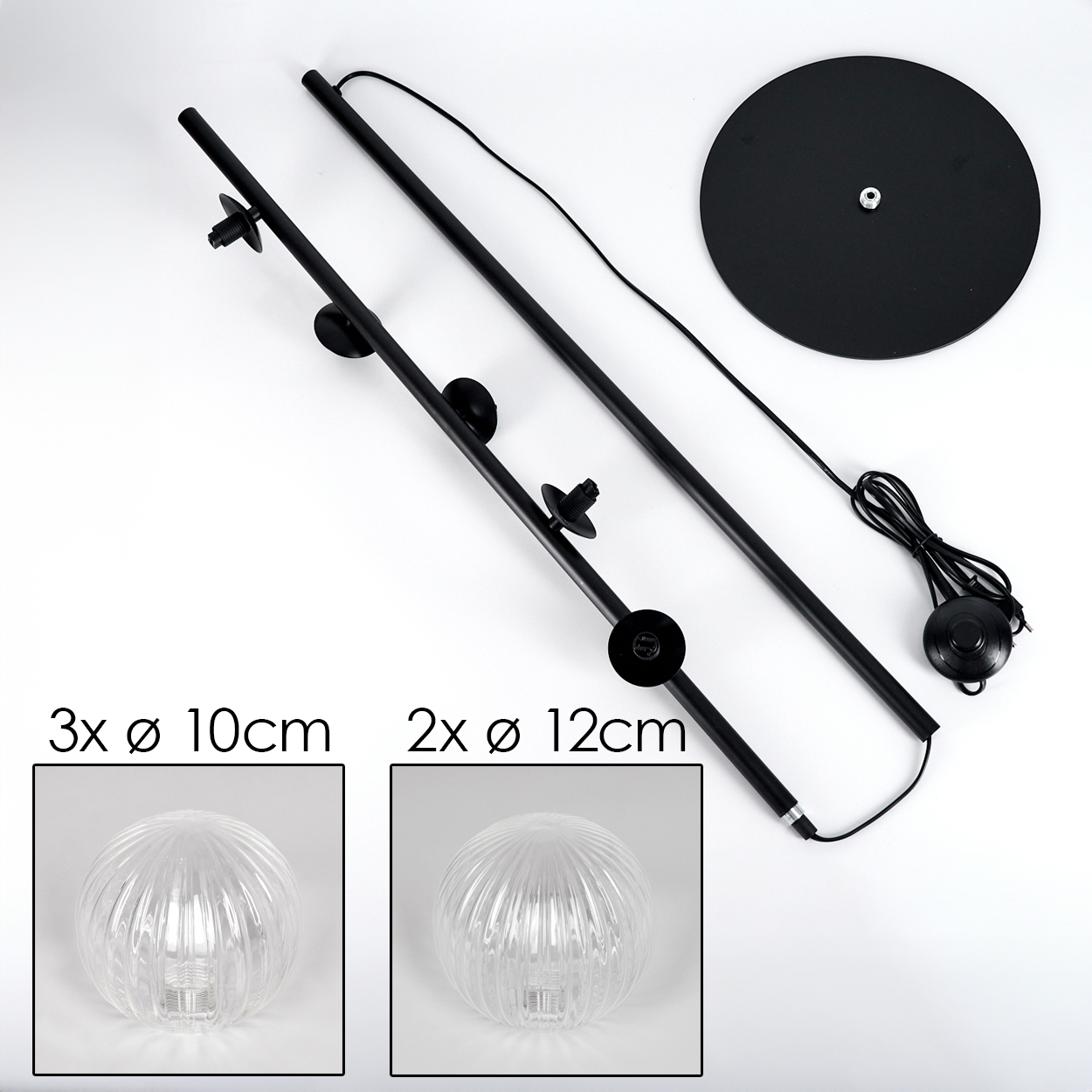 Zerlegte Stehlampe mit schwarzen Stangen, Sockel und Fußschalter sowie zwei Glaskugellampen. Weißer Hintergrund.