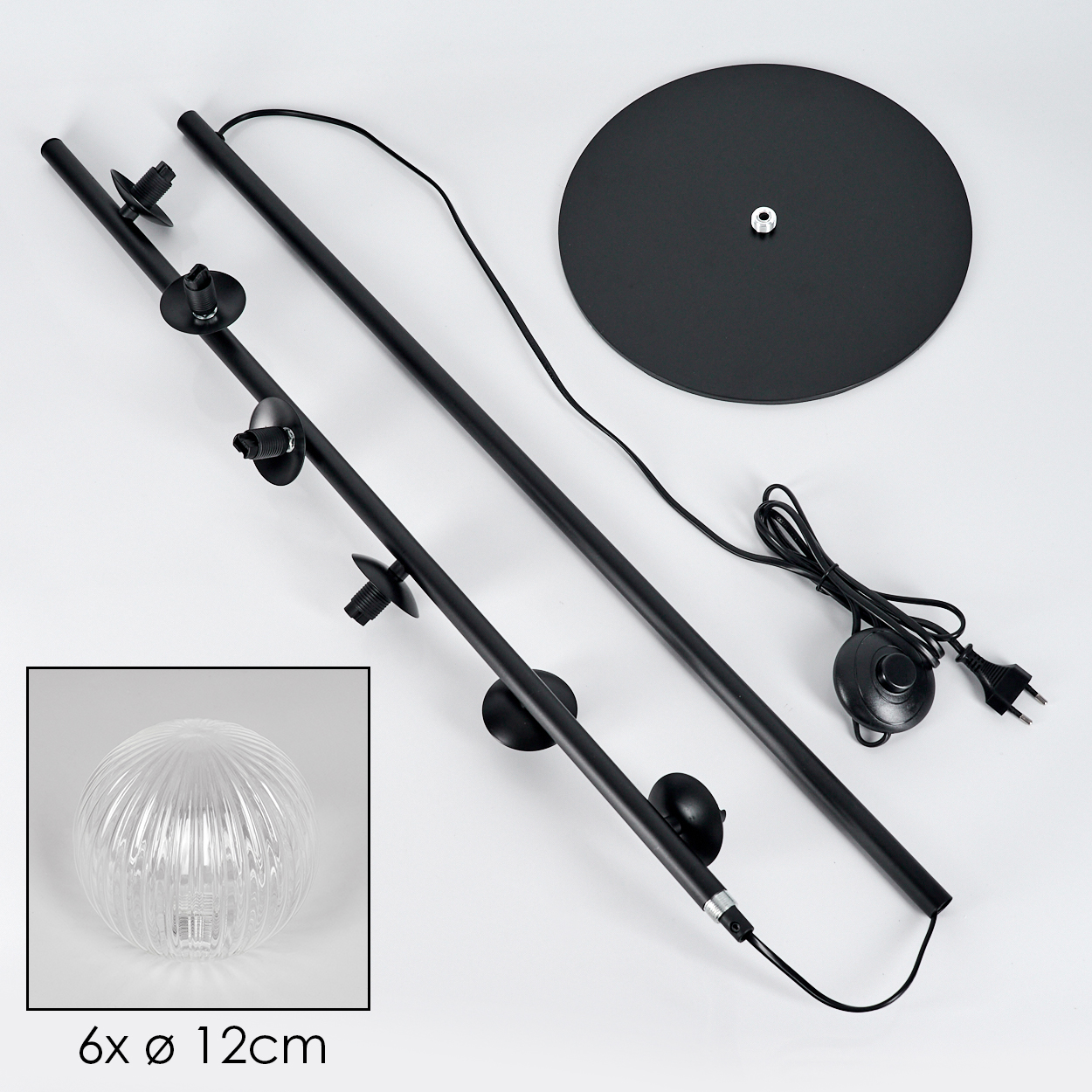 Zerlegte schwarze Stehlampe mit rundem Sockel, mehreren Stangen und einer durchsichtigen Glaskugel. Komponenten auf weißer Oberfläche.