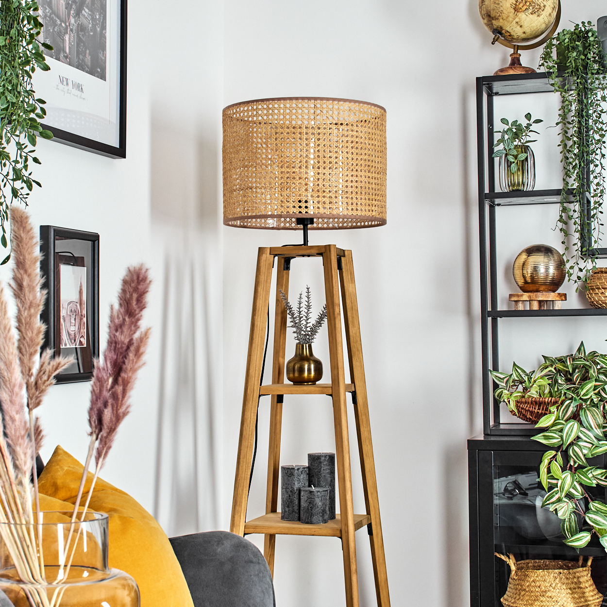 Eine Zimmerecke mit Holzlampe, Pflanzen und schwarzem Regal. Dekorative Elemente sind Kerzen und ein Globus.