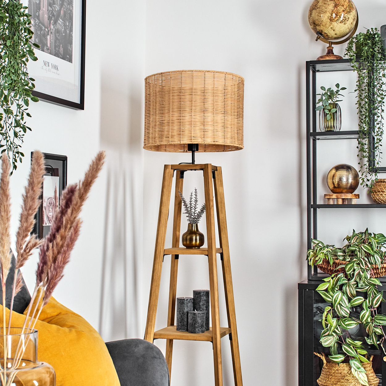 Eine Zimmerecke mit einer Holzlampe, Regalen und Pflanzen. Ein Globus und dekorative Gegenstände stehen auf den Regalen. Ein gelbes Kissen ist sichtbar.