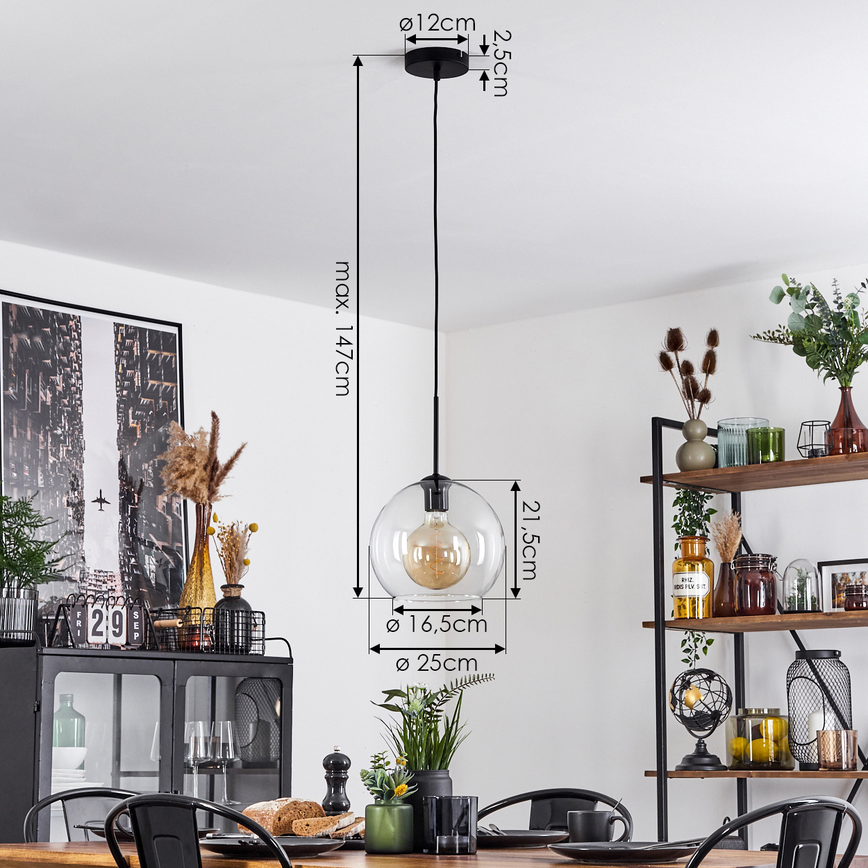 Esszimmer mit Glaskugel-Pendelleuchte. Tisch mit Stühlen. Schwarzer Schrank und Regal mit Dekorationen sind sichtbar.