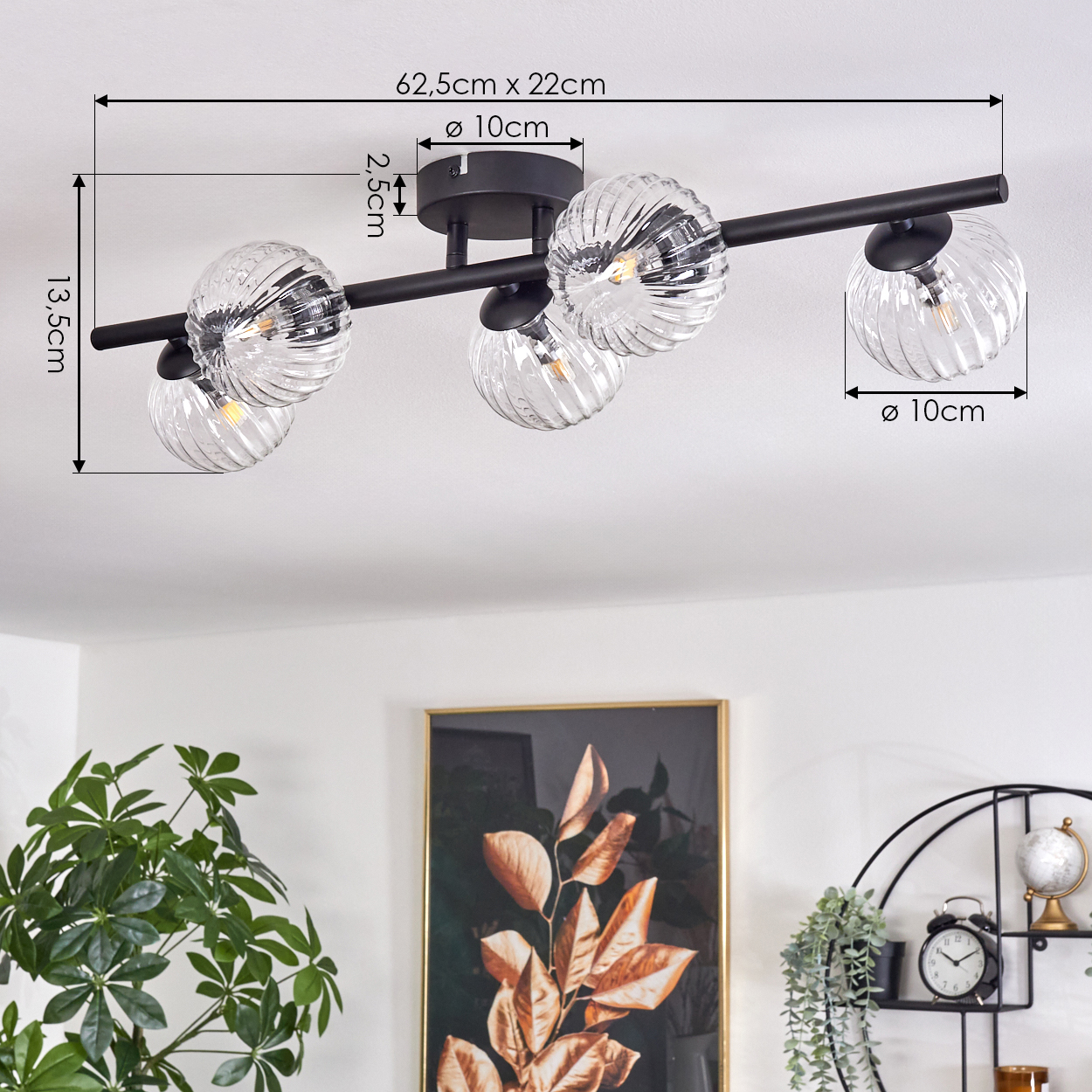 Deckenlampe mit 5 Glaskugeln. Schwarzer Rahmen, Maße auf dem Bild markiert. Im Hintergrund ein Gemälde und Dekorationsartikel.