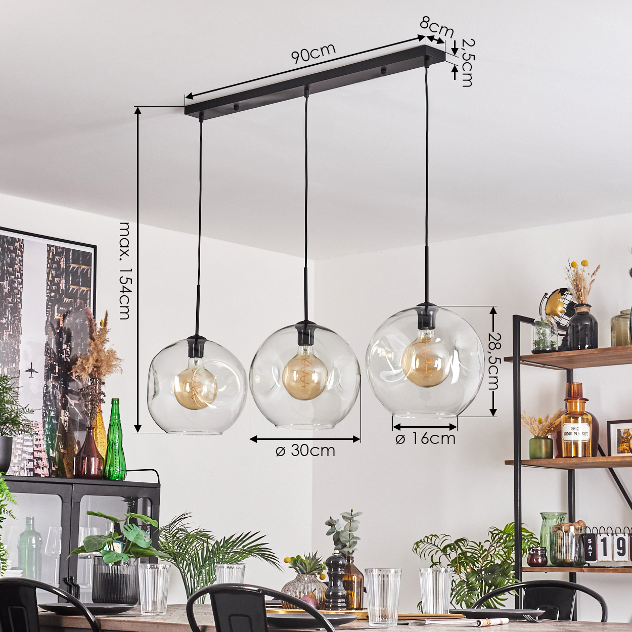 Drei Glas-Pendelleuchten mit Maßen. Darunter ein gedeckter Esstisch und rechts ein Regal mit Dekoration.