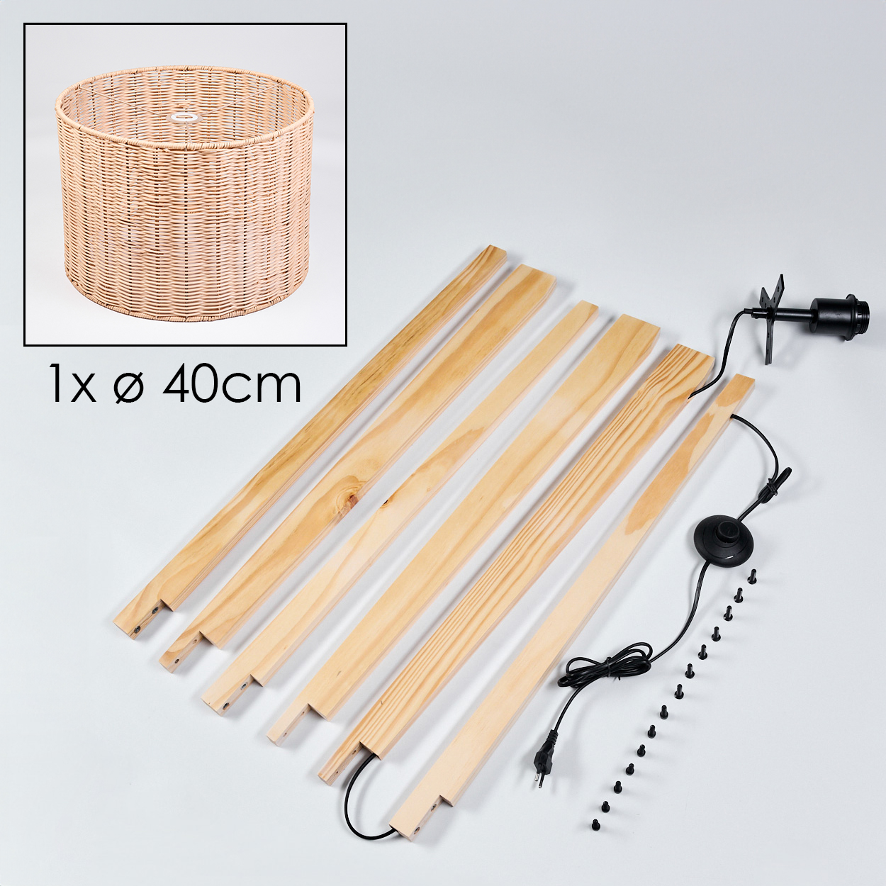 Eine zerlegte Lampe. Komponenten umfassen einen gewebten Lampenschirm, Holzlatten, eine Lampenfassung, einen Fußschalter, Schrauben und ein Netzkabel.