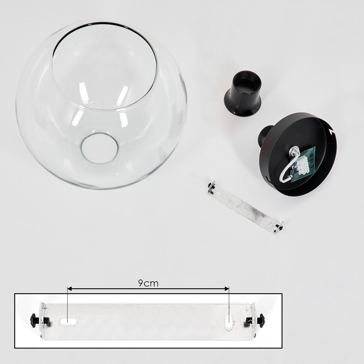 Draufsicht auf eine zerlegte Lampe. Enthält einen Glaskolben, schwarze Lampenteile, eine Metallhalterung und einen 9 cm Messanzeiger.