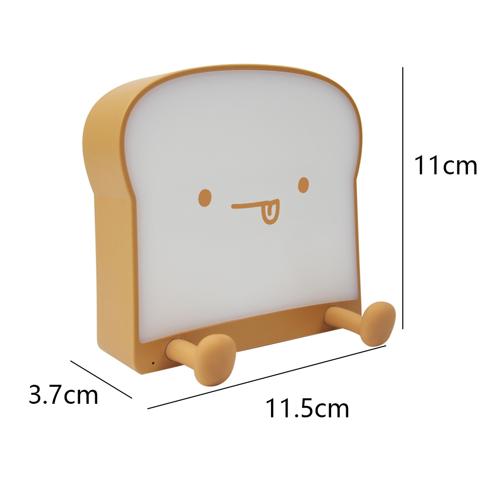 Eine brotförmige Lampe mit einem lächelnden Gesicht. Sie hat eine gelbbraune Farbe und die angegebenen Abmessungen: 11cm, 3,7cm und 11,5cm.