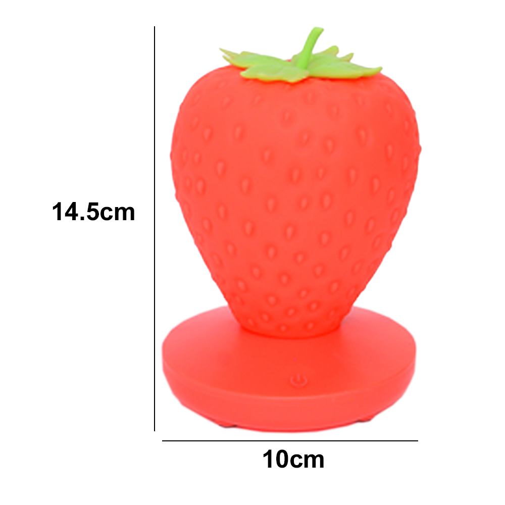 Eine rote Erdbeerlampe mit grünen Blättern oben, die auf einem runden Sockel steht. Die Maße sind 14,5 cm hoch und 10 cm breit.
