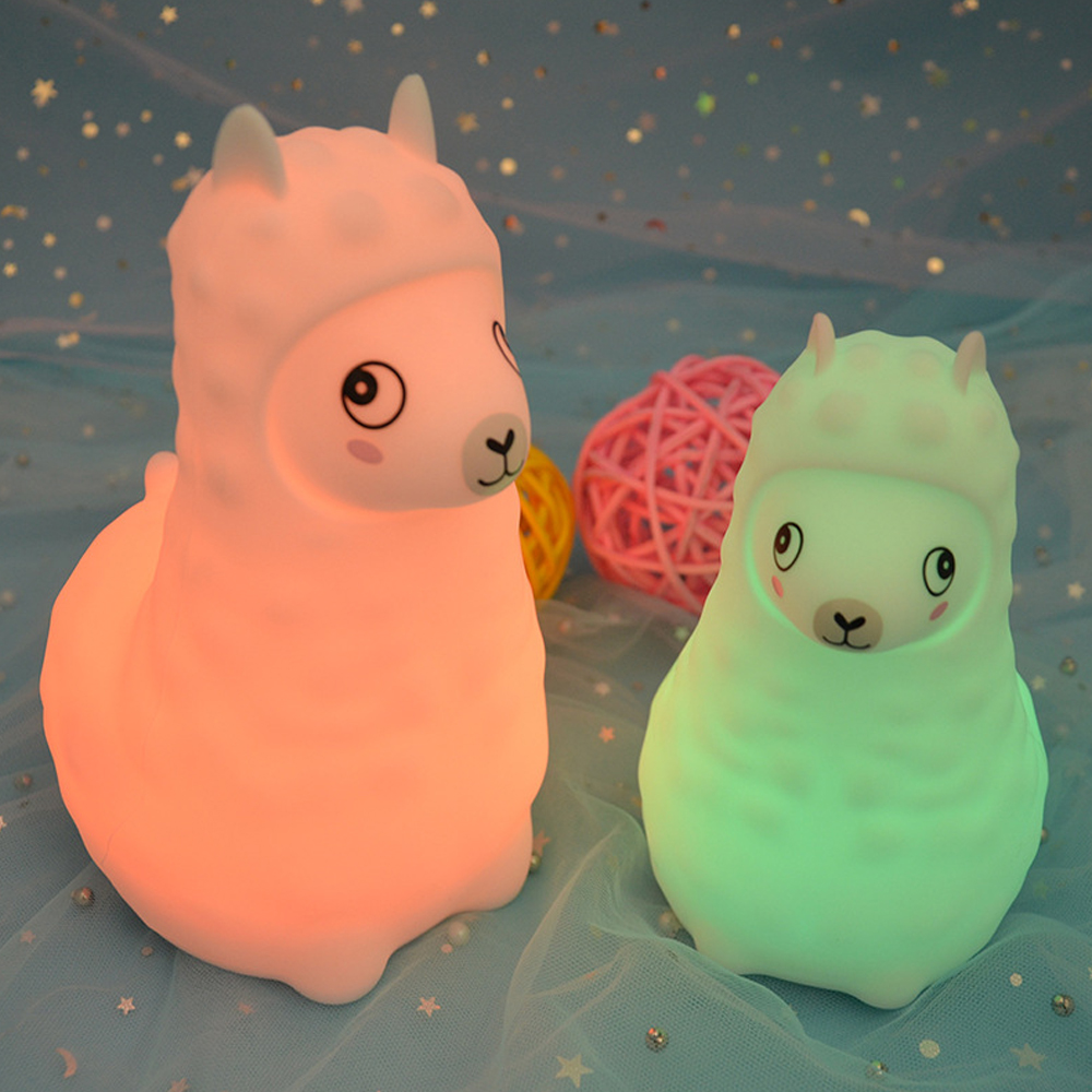 Zwei Nachttischlampen in Lama-Form. Eine ist rosa, eine ist grün. Im Hintergrund Sterne und ein rosa und gelber Ball.