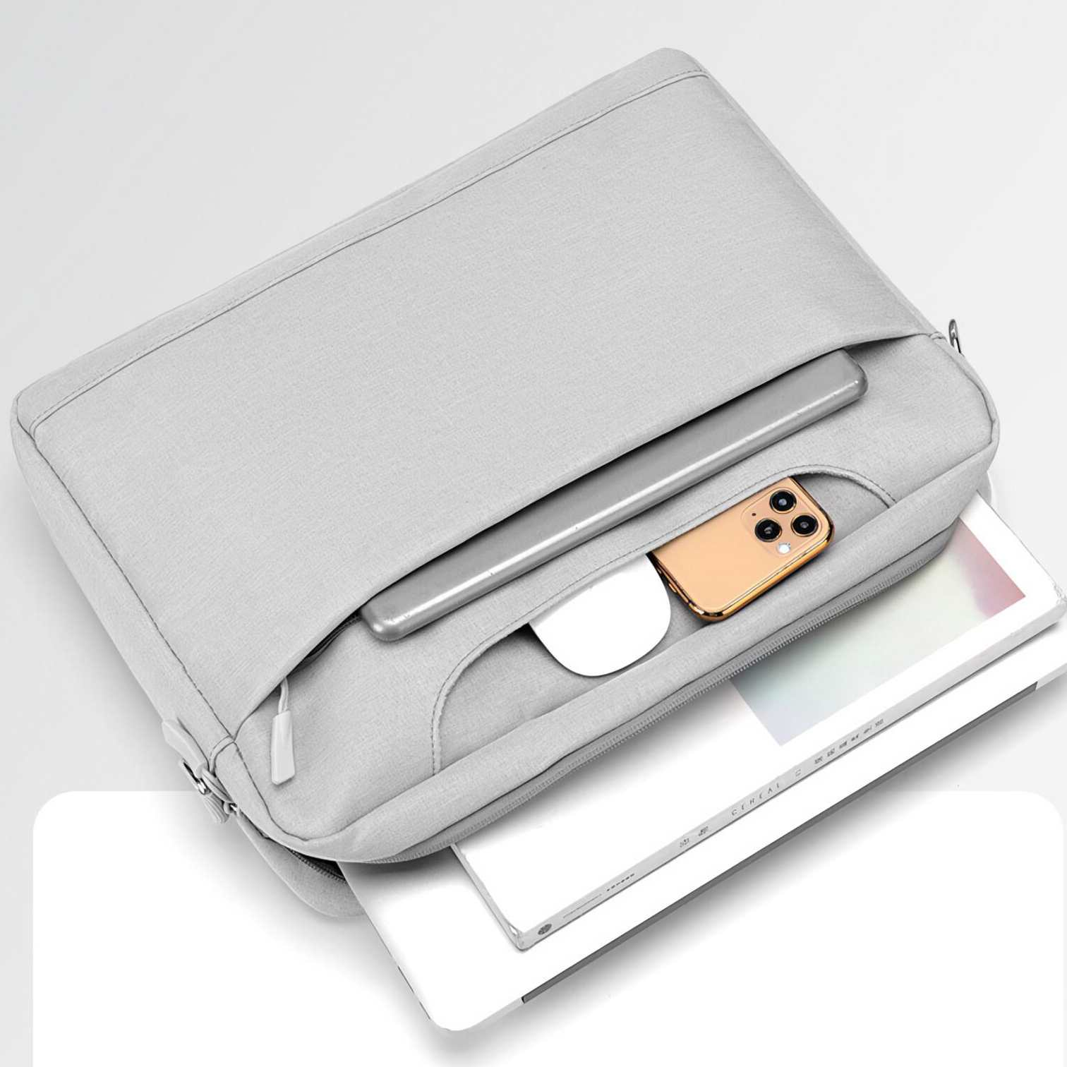 Eine graue Laptoptasche mit Tablet, Telefon und Maus in der Tasche. Ein Laptop und ein Buch befinden sich in der Tasche.