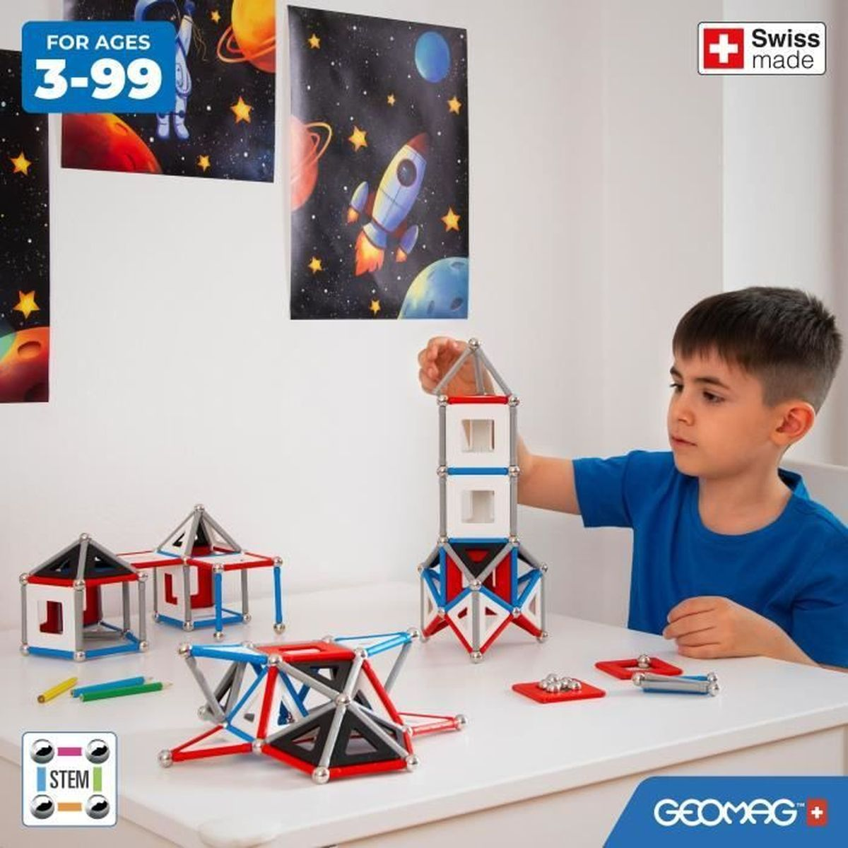 Ein Junge baut mit bunten magnetischen Konstruktionsspielzeugen. Weltraum-Poster hängen dahinter. Ein Logo „Swiss made“ ist an der Wand.