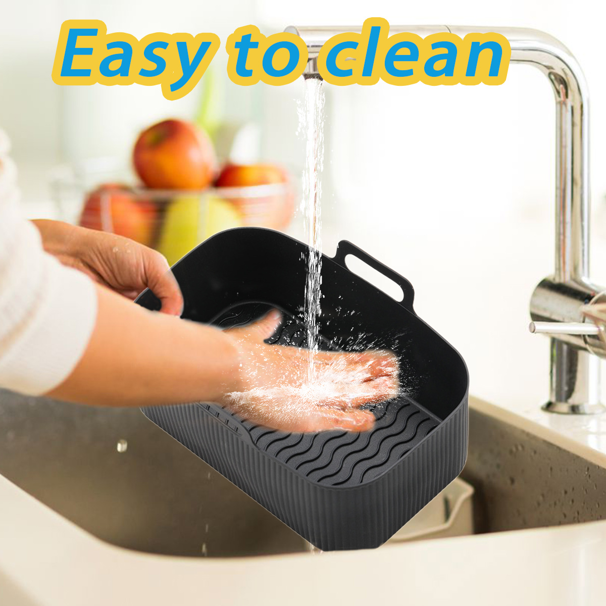 Eine Person wäscht einen schwarzen Korb unter einem Wasserhahn. Wasser spritzt auf die Hand im Korb. Früchte sind im Hintergrund.