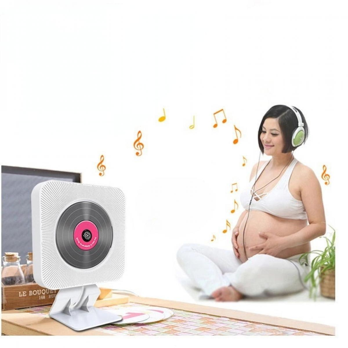 Schwangere Frau mit Kopfhörern hört Musik. Ein CD-Player befindet sich im Vordergrund. Noten sind vorhanden.