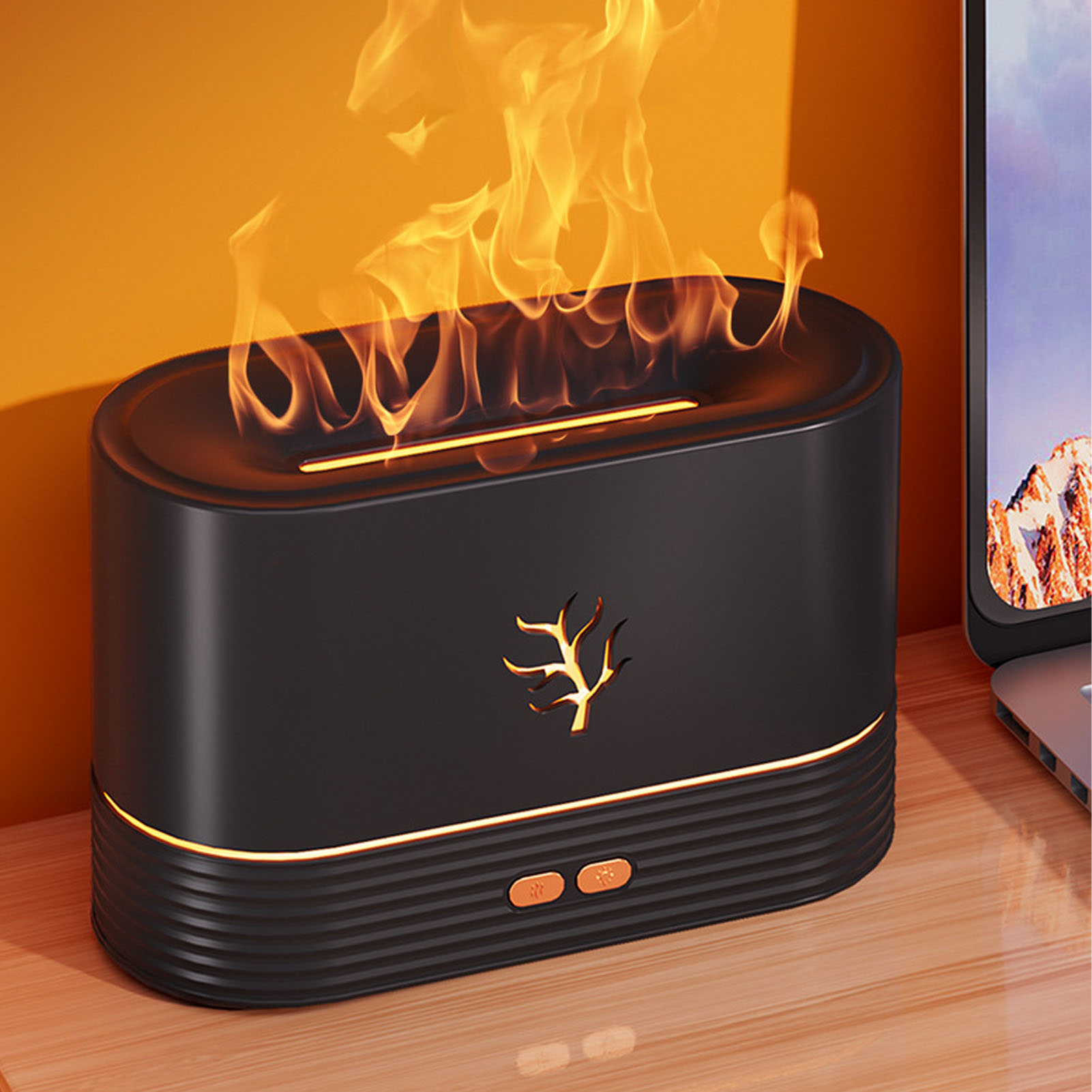Ein schwarzer Flammen-Luftbefeuchter mit orangefarbenen Flammen auf einer Holzoberfläche neben einem Laptop.
