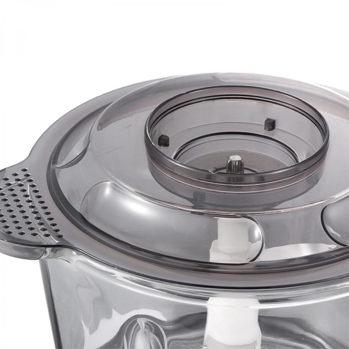 Nahaufnahme eines Food-Processors. Der transparente Deckel und die Schüssel sind sichtbar. Das Design umfasst eine kreisförmige Öffnung und eine weiße Klinge.