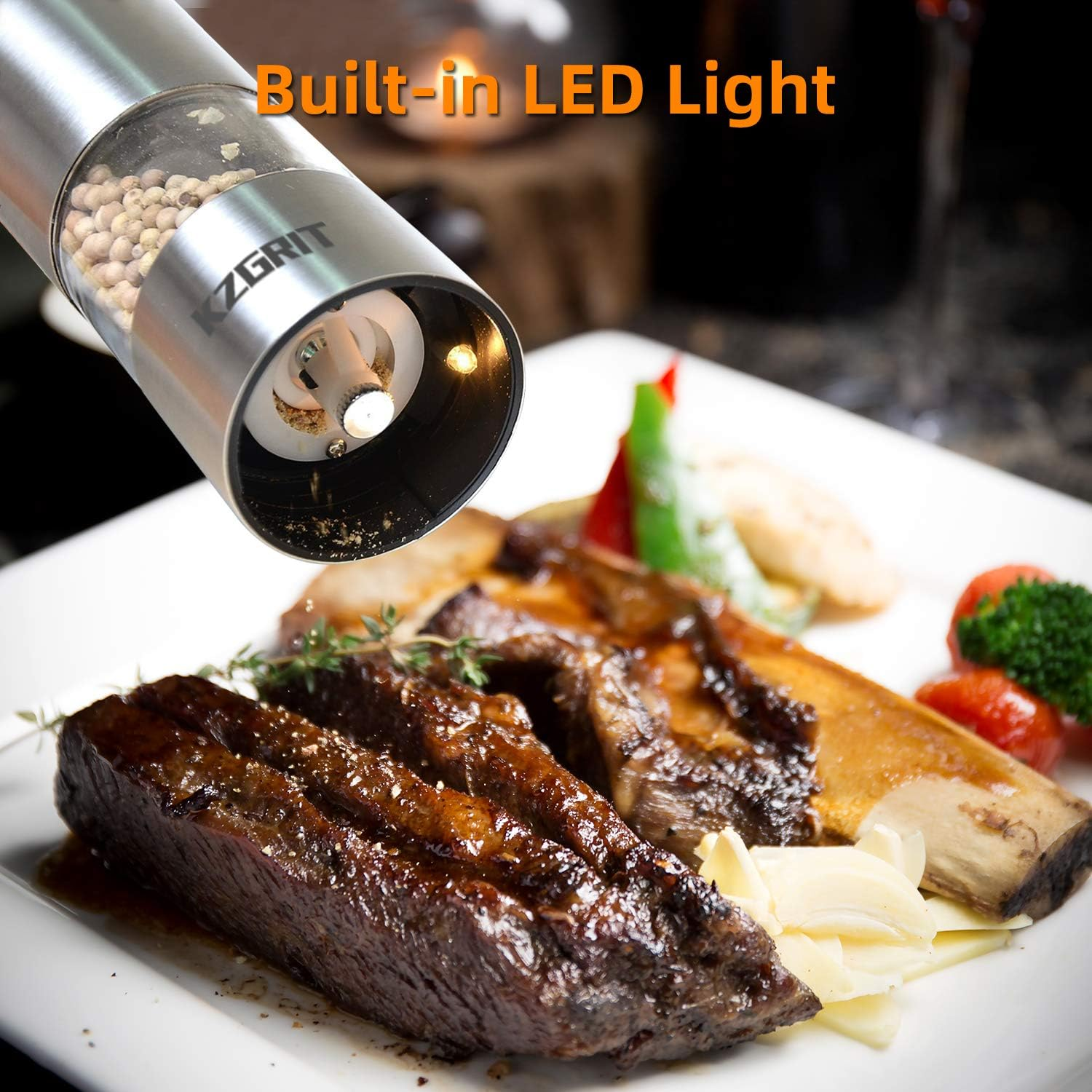 Eine Pfeffermühle mit LED-Licht mahlt Pfeffer über geschmorten Rindfleischrippen auf einem weißen Teller. Gemüse auf dem Teller.