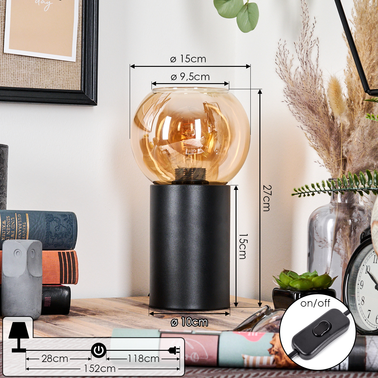 Eine schwarze Lampe mit bernsteinfarbenem Schirm steht auf einer Holzoberfläche. Maße sind beschriftet. Bücher und eine Eulenstatue im Hintergrund.