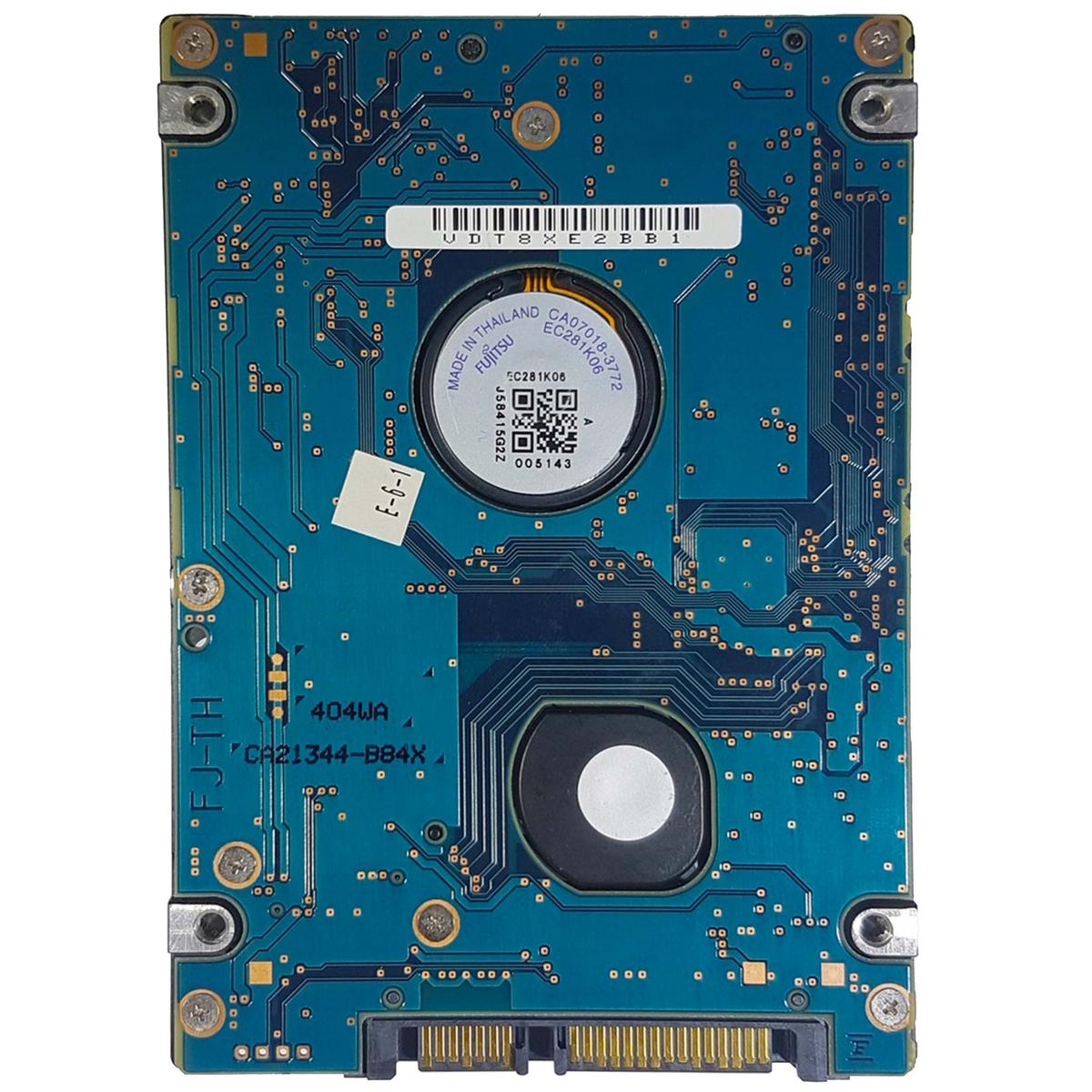 Un circuito stampato blu con chip, un adesivo e un'etichetta rotonda, con testo bianco e un connettore in basso.