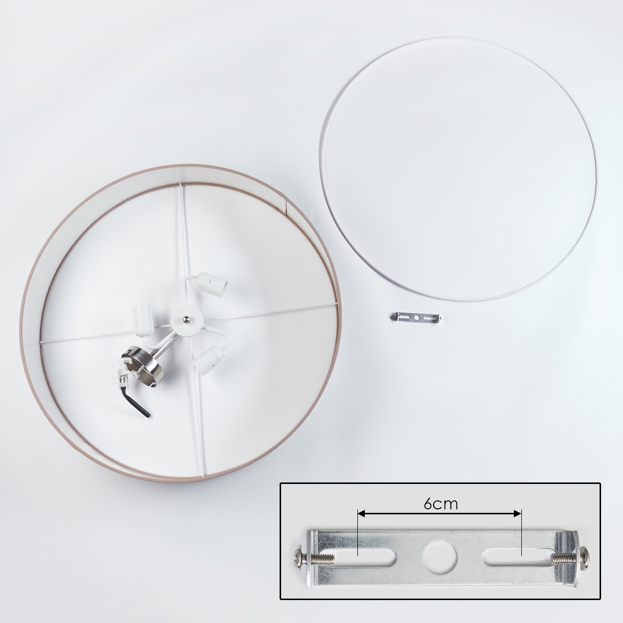 Draufsicht einer zerlegten Lampe. Komponenten umfassen einen Lampenschirm, einen kreisförmigen Rahmen und eine Halterung mit 6 cm Messung.