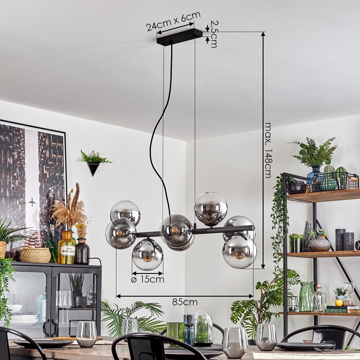 Eine moderne Deckenleuchte mit sechs kugelförmigen Lichtern. Sie hängt über einem Esstisch mit Gläsern und Dekor. Regale mit Pflanzen sind im Hintergrund.