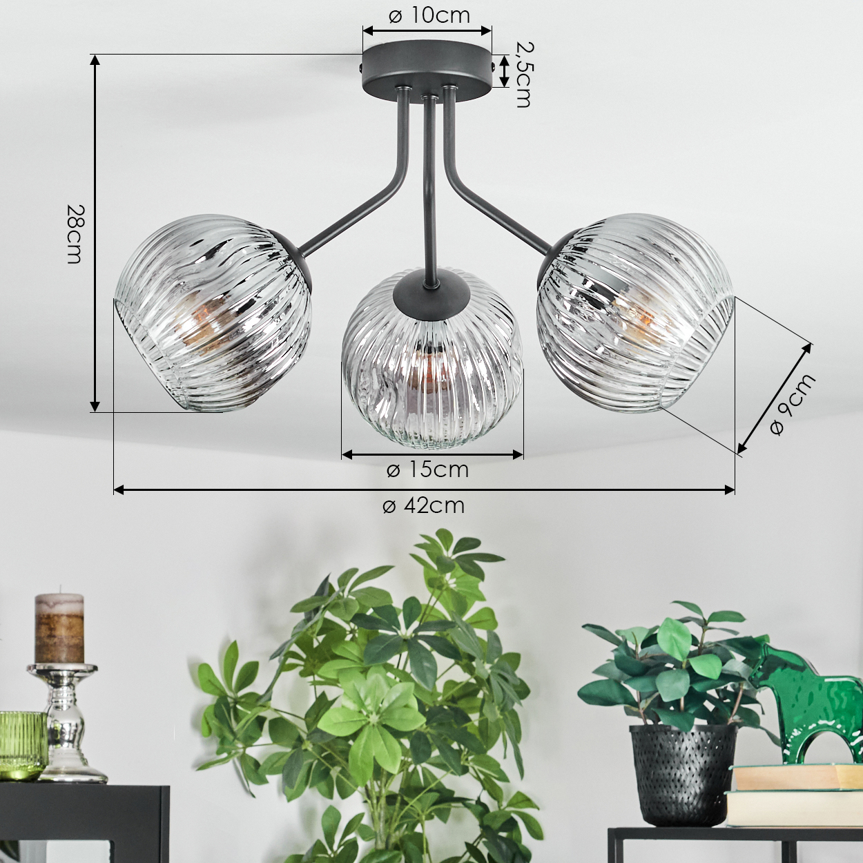 Moderne Deckenlampe mit drei Glaskugeln. Maße sind angegeben. Pflanzen und Dekoration im Vordergrund.