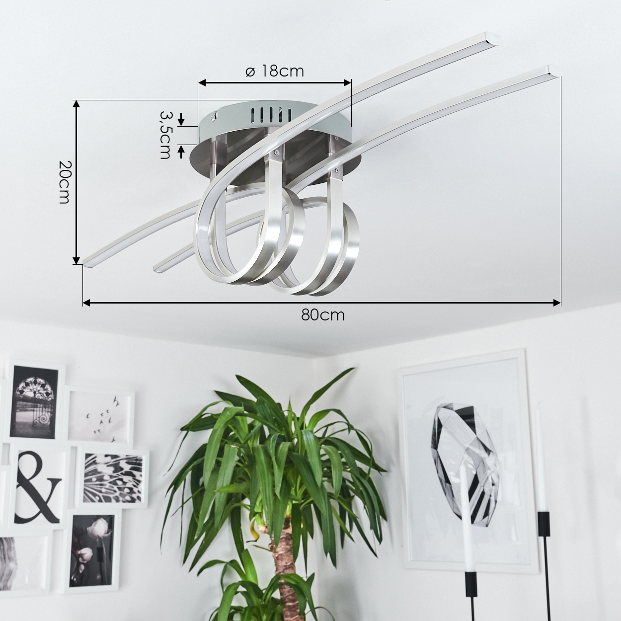 Moderne Deckenleuchte in Silber. Pflanze und gerahmte Kunst im Vordergrund. Abmessungen sind angegeben.