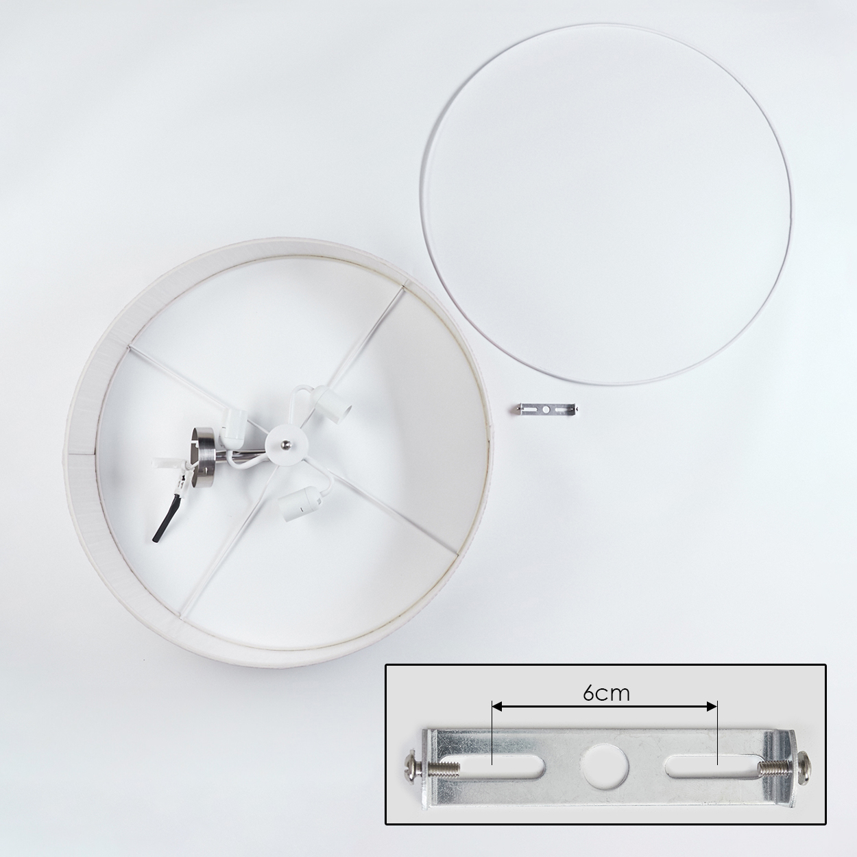 Draufsicht einer zerlegten Lampe. Schirm, Gestell und Halterung sind vor weißem Hintergrund sichtbar. Halterung ist 6 cm lang.