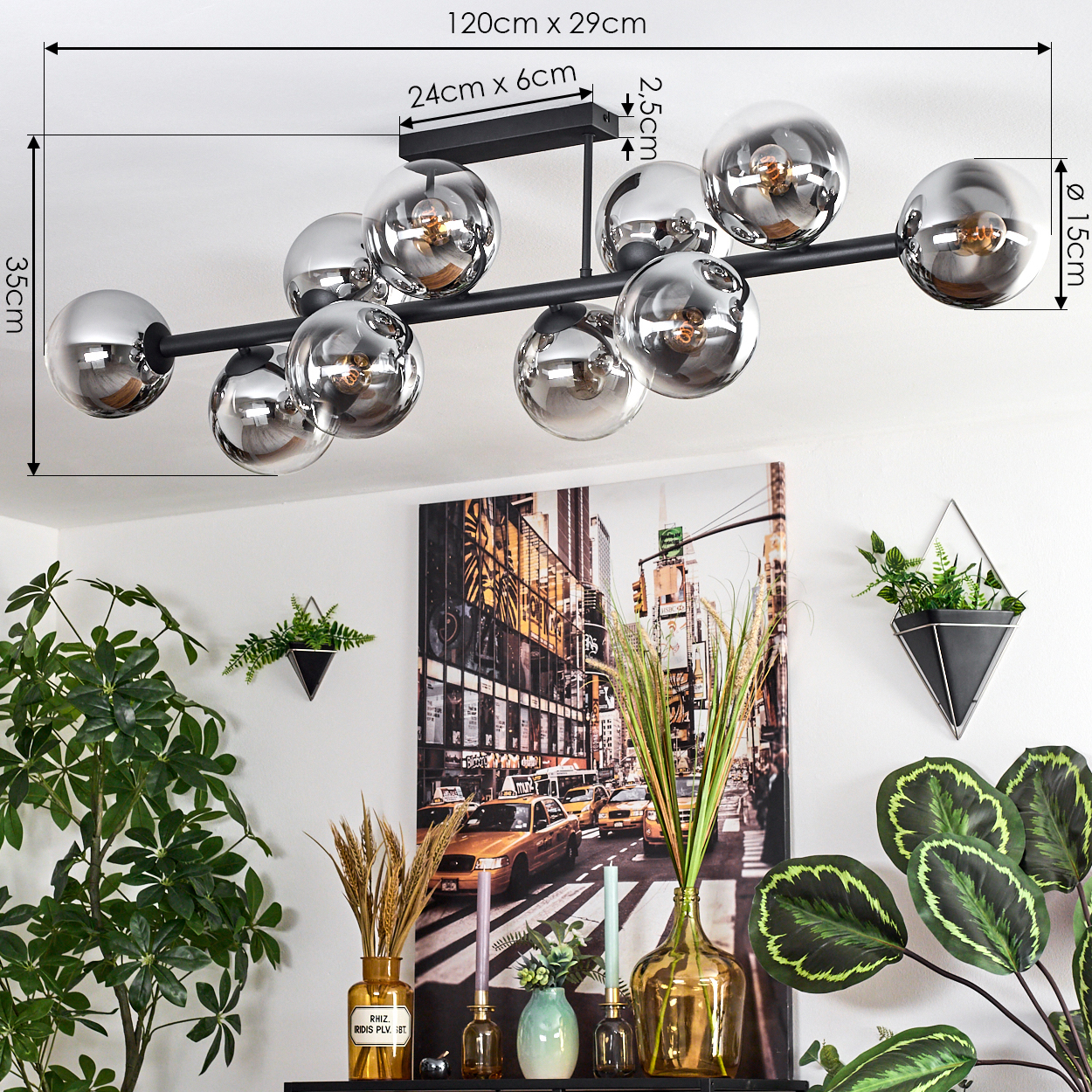 Moderne schwarze Deckenlampe mit Chromkugeln. Darunter ein Stadtbildgemälde mit gelben Taxis, Pflanzen und Vasen.