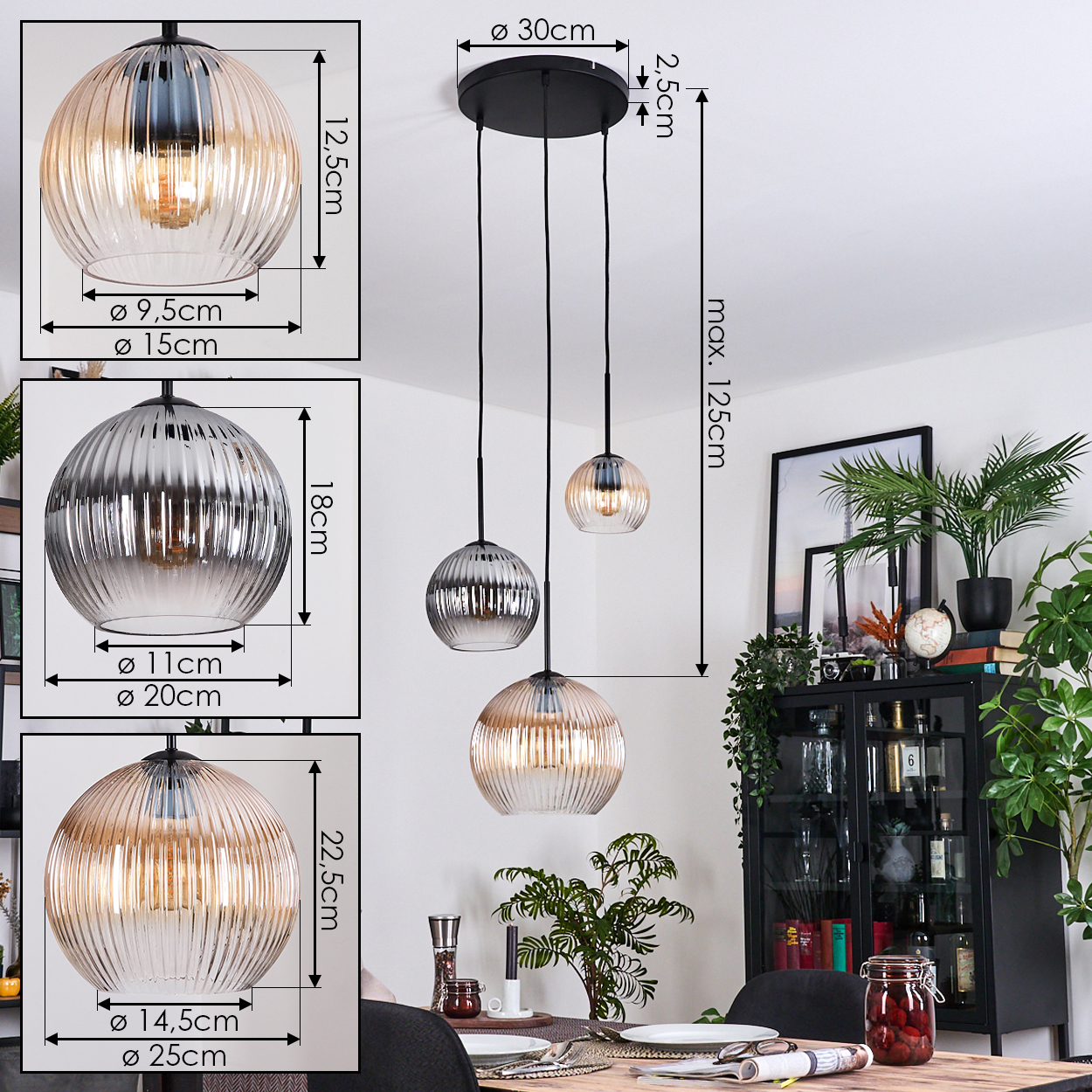 Drei Pendelleuchten mit Glasschirmen hängen an einer schwarzen Deckenhalterung. Im Hintergrund befinden sich ein Esstisch und ein Schrank.