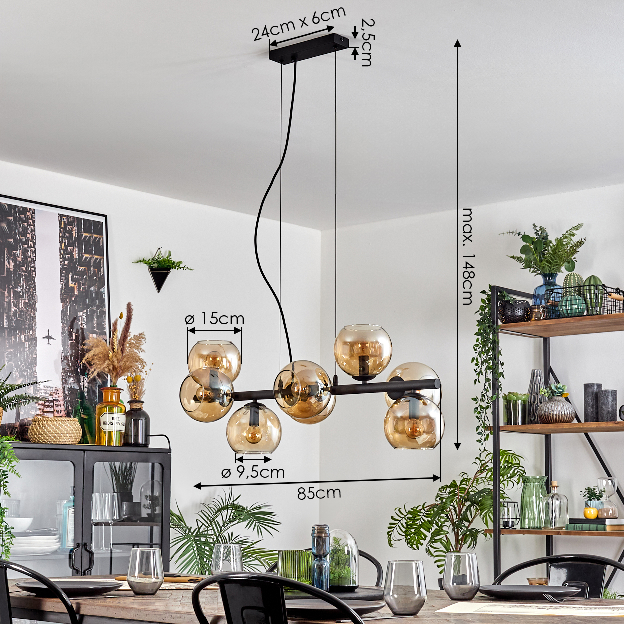 Ein modernes Esszimmer mit einem schwarzen Kronleuchter mit Glaskugeln, einem Holztisch und dekorativen Pflanzen.