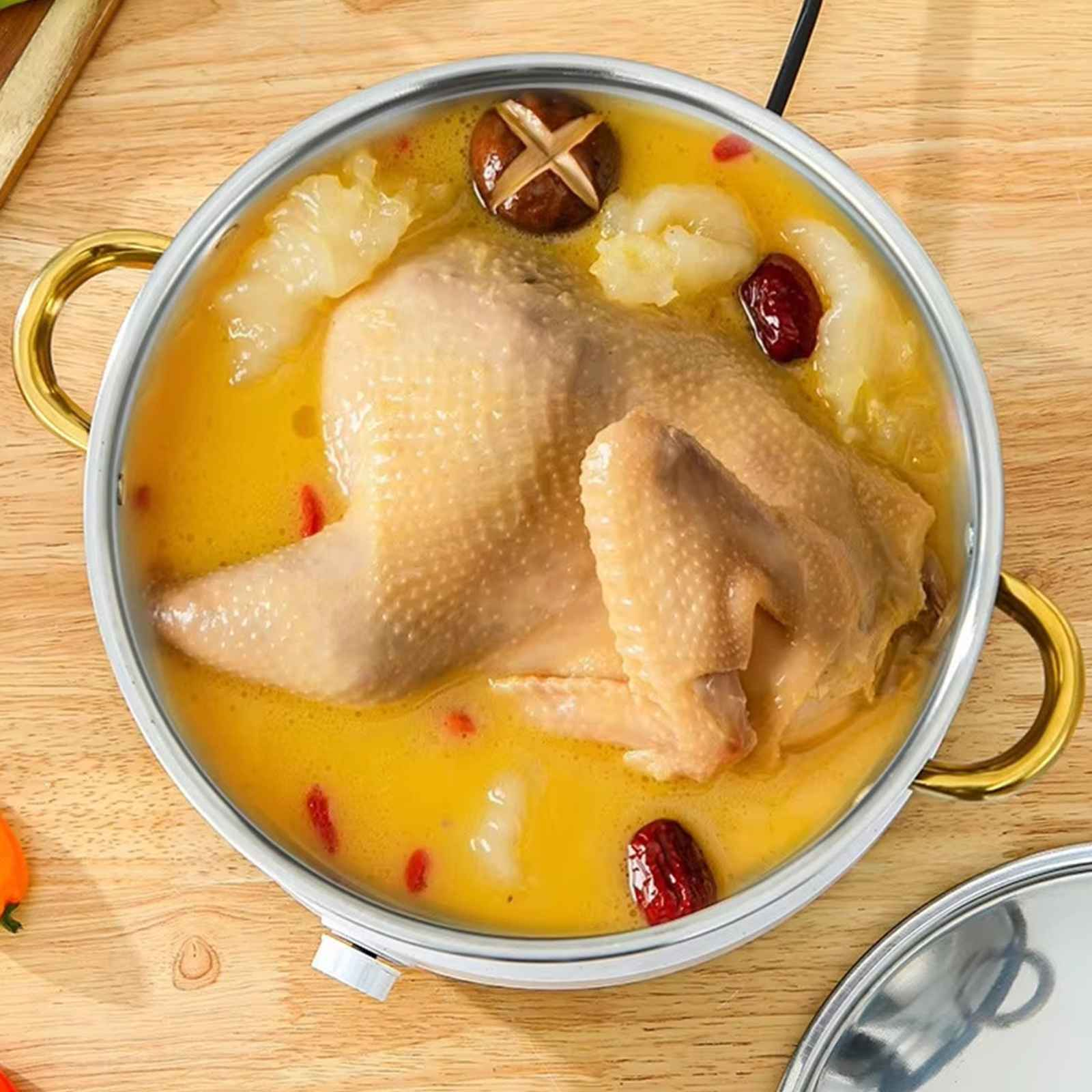 Hühnchen in einem Topf mit Brühe, Pilzen und Datteln. Auf einer Holzoberfläche.
