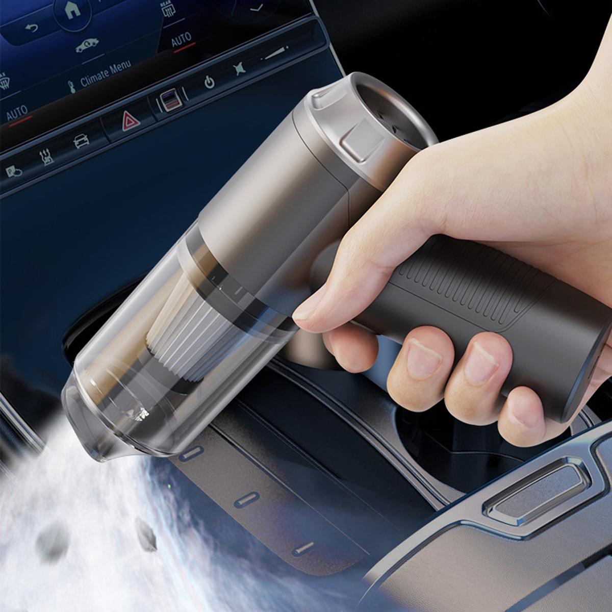 Eine Hand hält einen silber-schwarzen Staubsauger in einem Auto. Der Staubsauger ist auf die Mittelkonsole gerichtet.