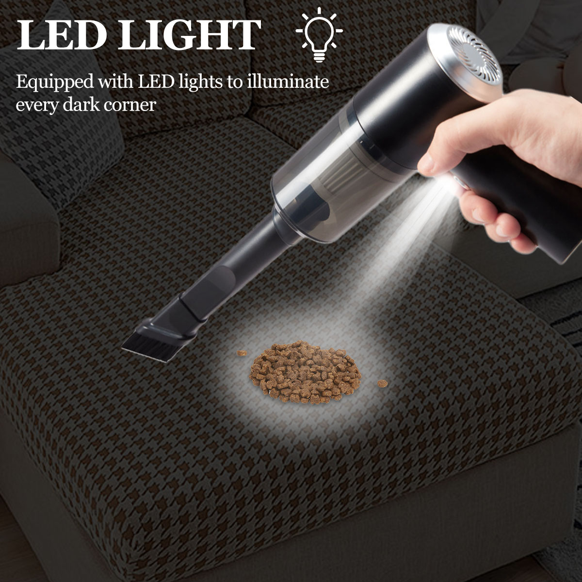 Ein Handstaubsauger mit LED-Licht beleuchtet Tierfutterkrümel auf einer gemusterten Couch. Eine Hand hält den schwarzen Staubsauger.
