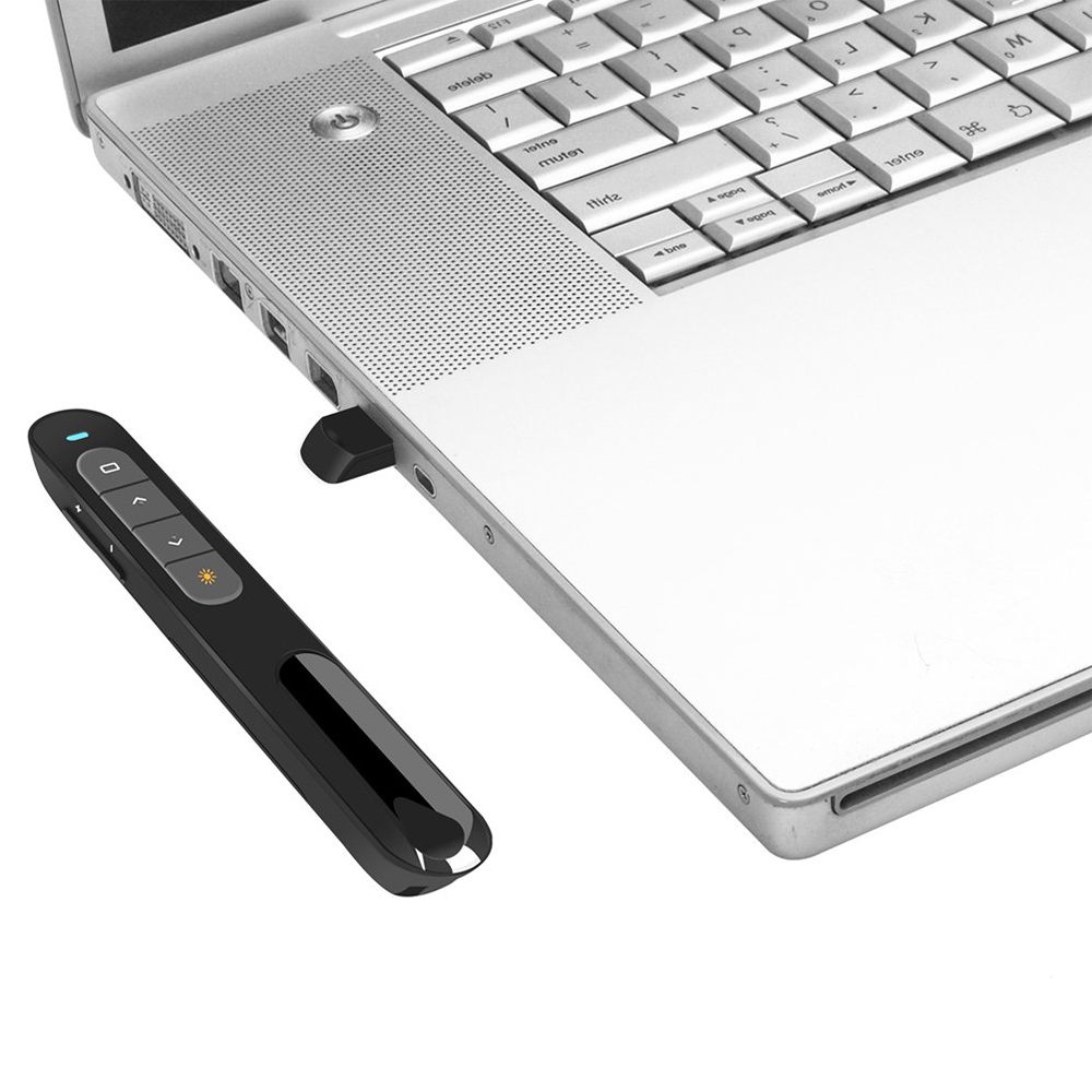 Eine schwarze Präsentationsfernbedienung und ein USB-Empfänger sind mit einem silbernen Laptop verbunden. Die Fernbedienung liegt links.