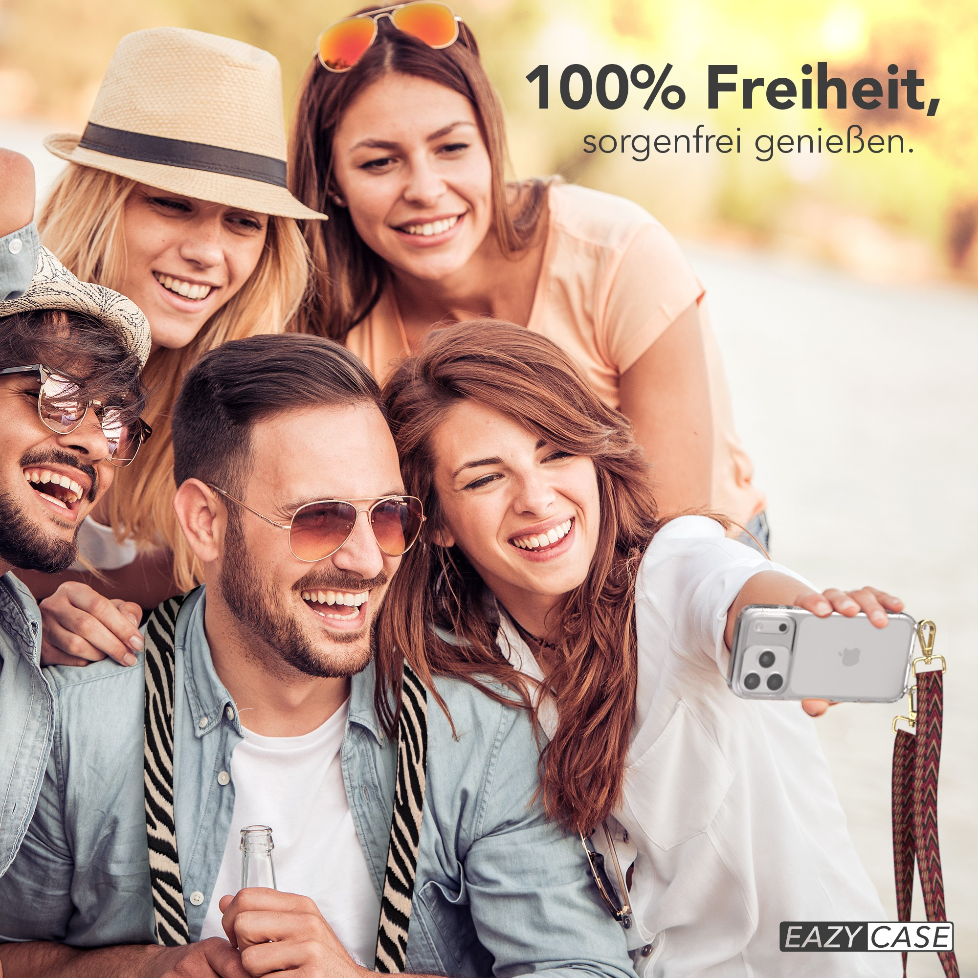 Freundesgruppe macht Selfie, lächelt. Eine Person hält das Telefon. Text: 100% Freiheit, unbeschwert genießen.
