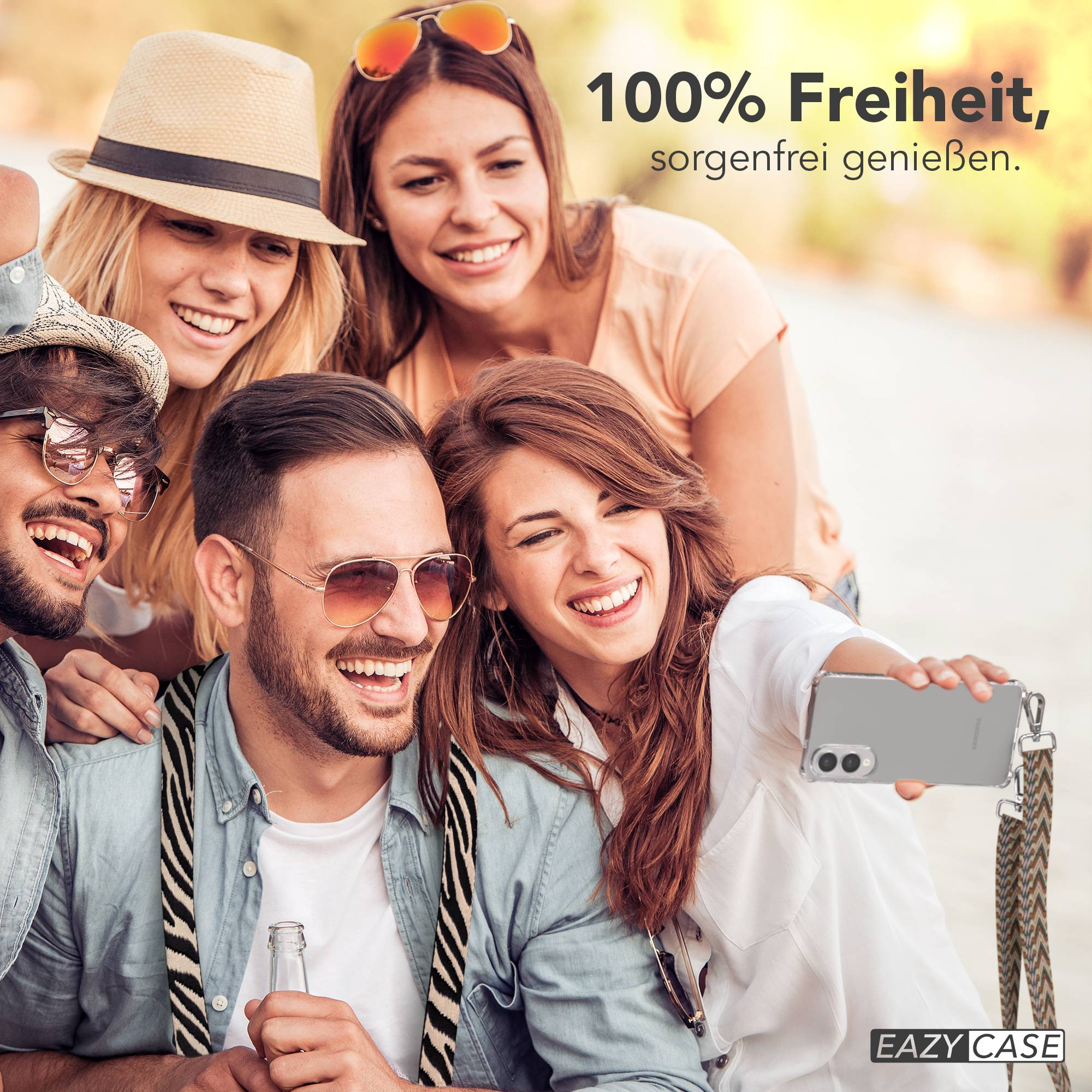 Freunde machen Selfie, lächeln. Einer hält das Telefon mit Gurt. Hintergrund unscharf mit Text.