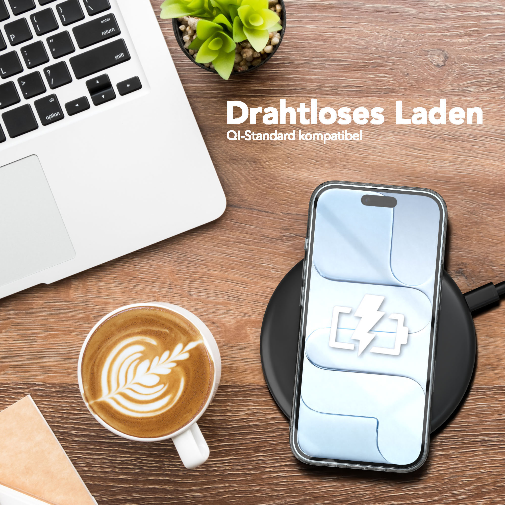 Ein Telefon auf einem kabellosen Ladegerät mit Akkusymbol, ein Laptop und ein Latte auf einem Holztisch.