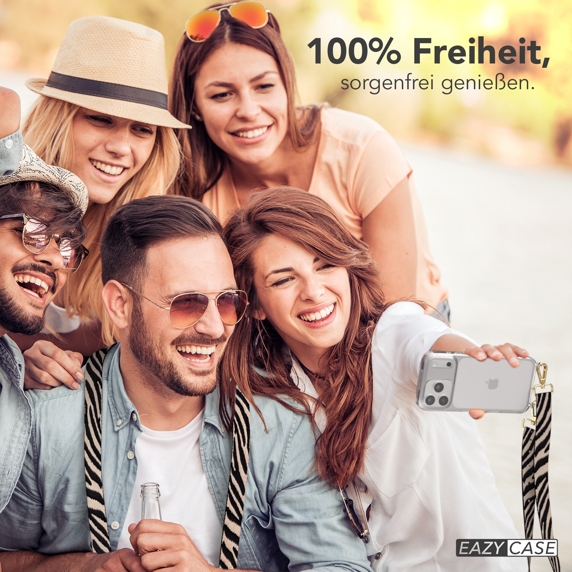 Freundesgruppe macht Selfie, lächelt. Einer hält das Telefon mit Zebra-Streifen.