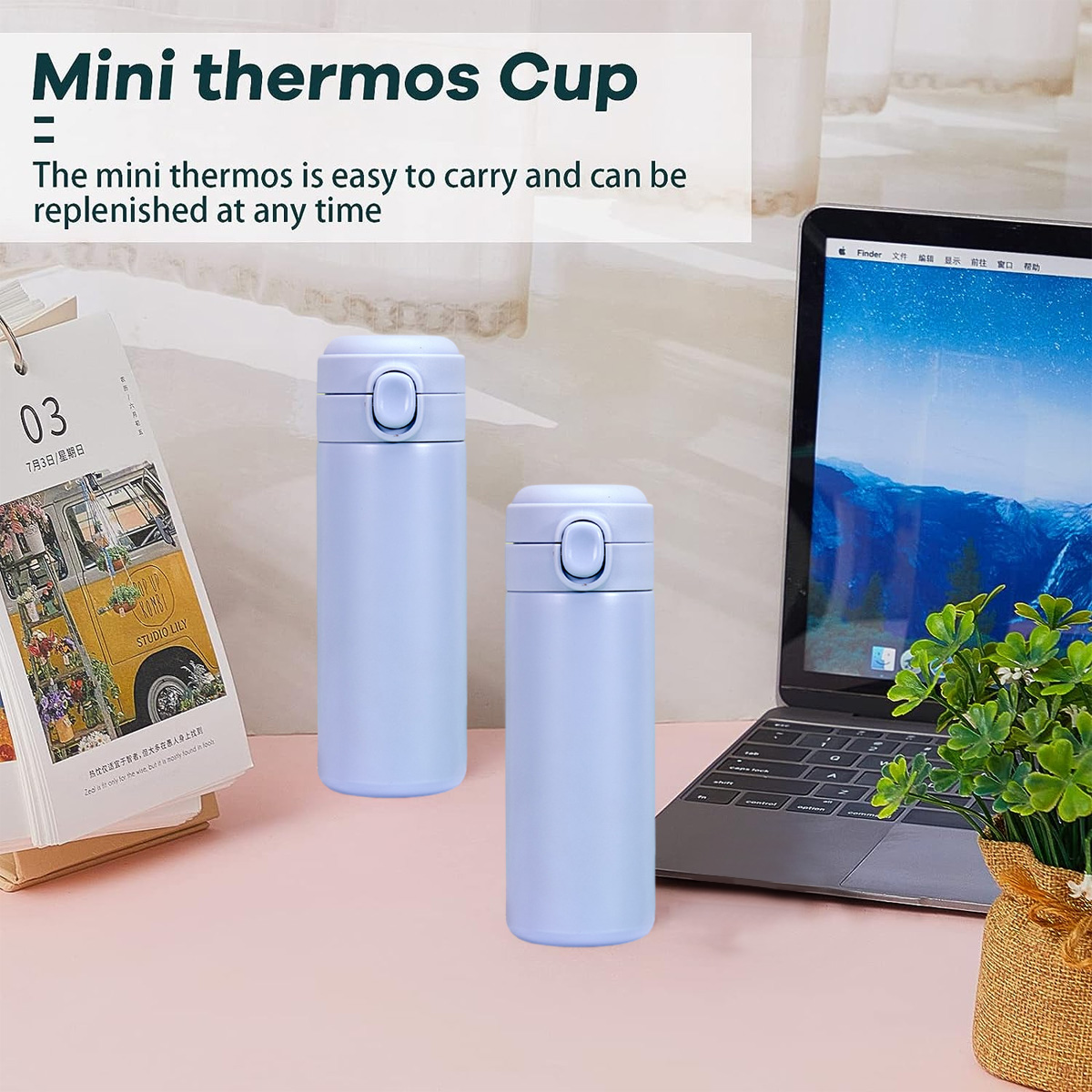 Zwei hellblaue Mini-Thermoskannen auf einer rosa Oberfläche. Ein Laptop, ein Kalender und ein Blumentopf befinden sich im Hintergrund.