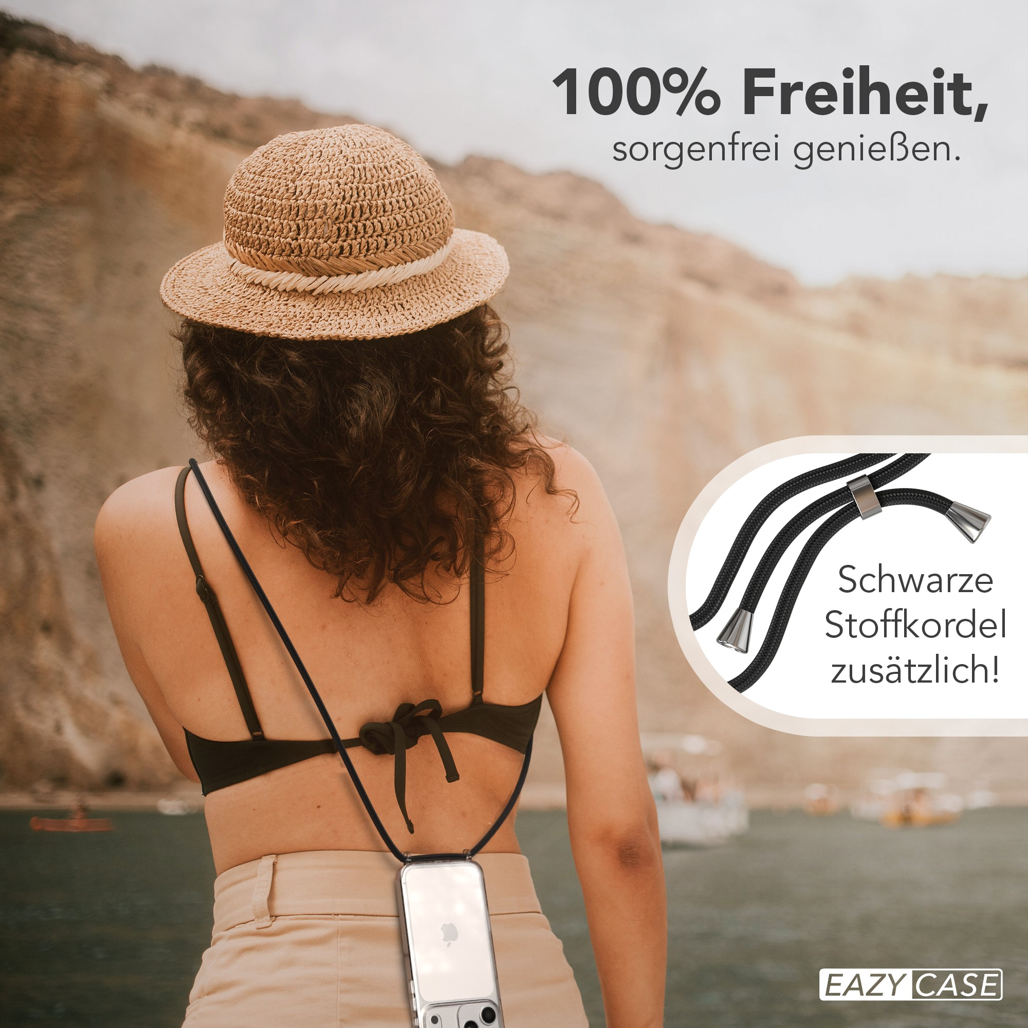 Eine Frau mit Hut und schwarzem Oberteil, die ein Telefon mit einem Lanyard hält. Hintergrund hat Berge und Wasser.