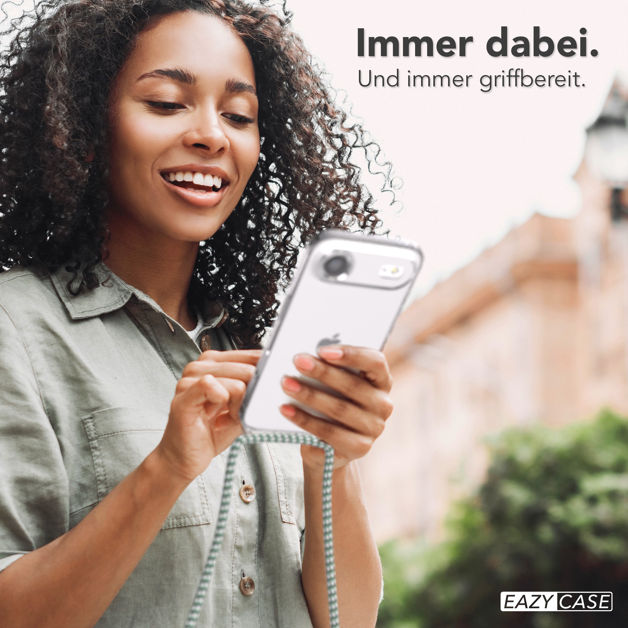 Lächelnde Frau, die ein Telefon mit einer transparenten Hülle hält. Der Hintergrund ist verschwommen, der Text lautet 'Immer dabei'.