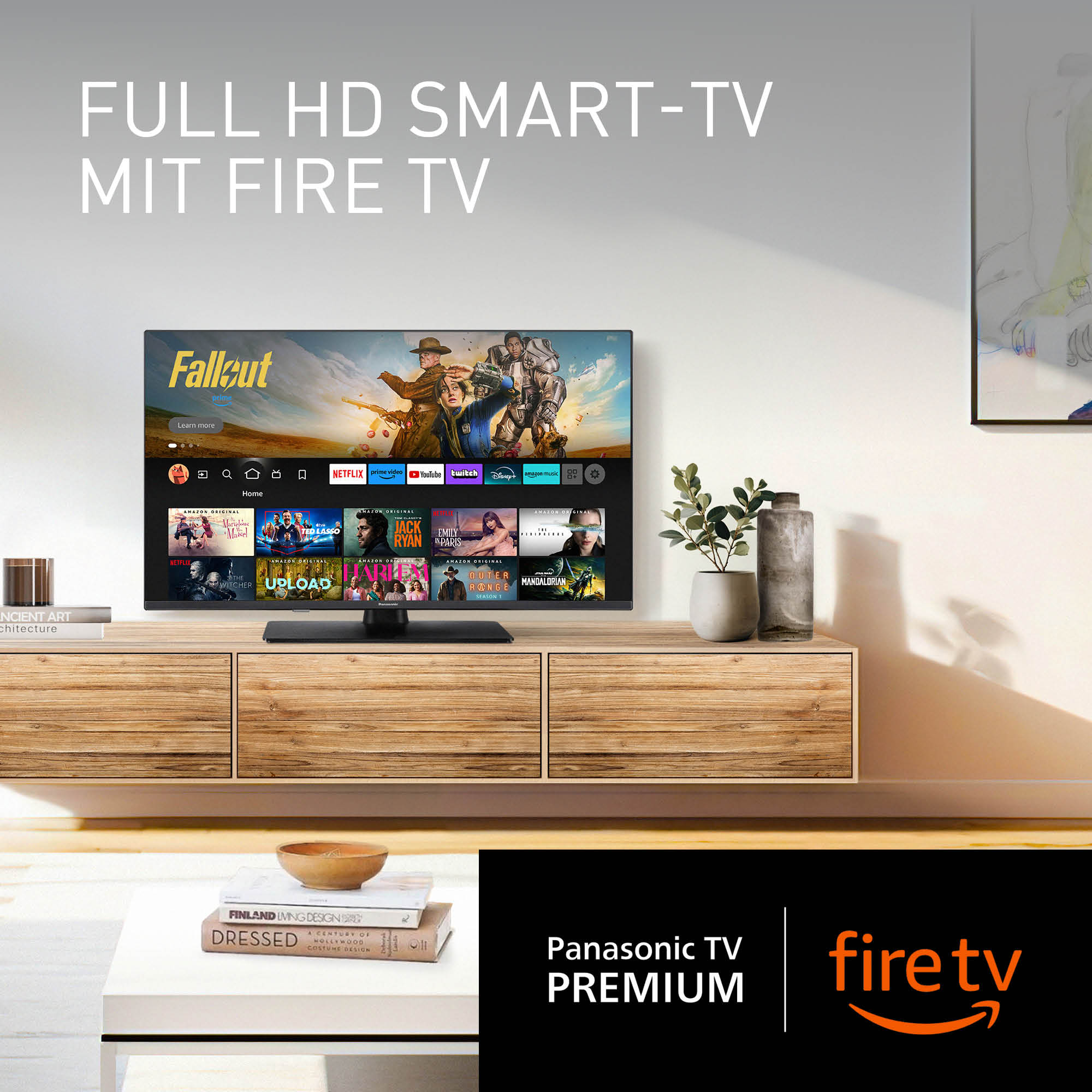 Ein Fernseher zeigt die Fallout-Serie. Der Fernseher steht auf einem Holzschrank mit Pflanzen und Büchern. Die Marke ist Panasonic und Fire TV.