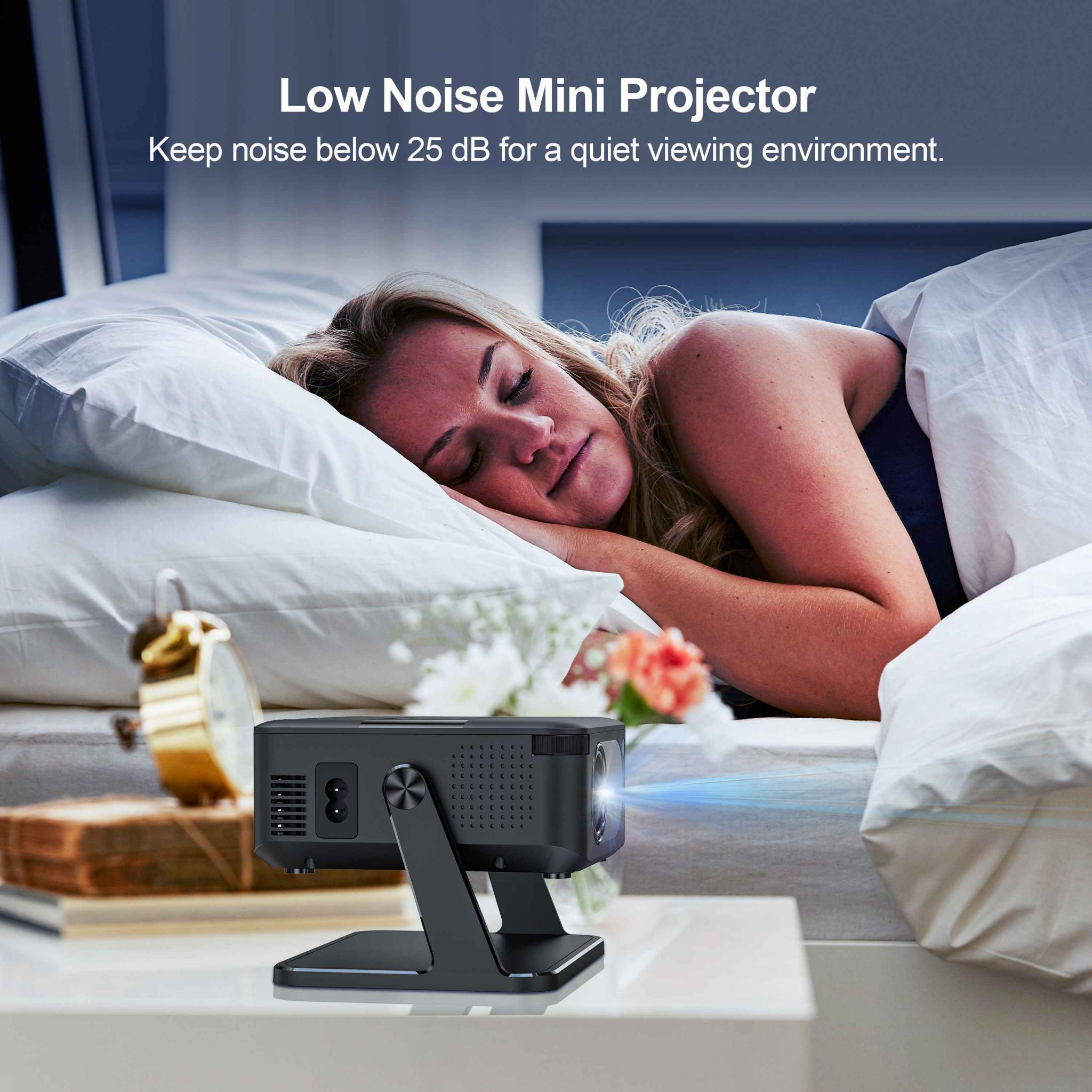Eine Frau schläft im Bett neben einem Nachttisch mit einem Mini-Projektor. Der Text lautet: Geräuscharmer Mini-Projektor.